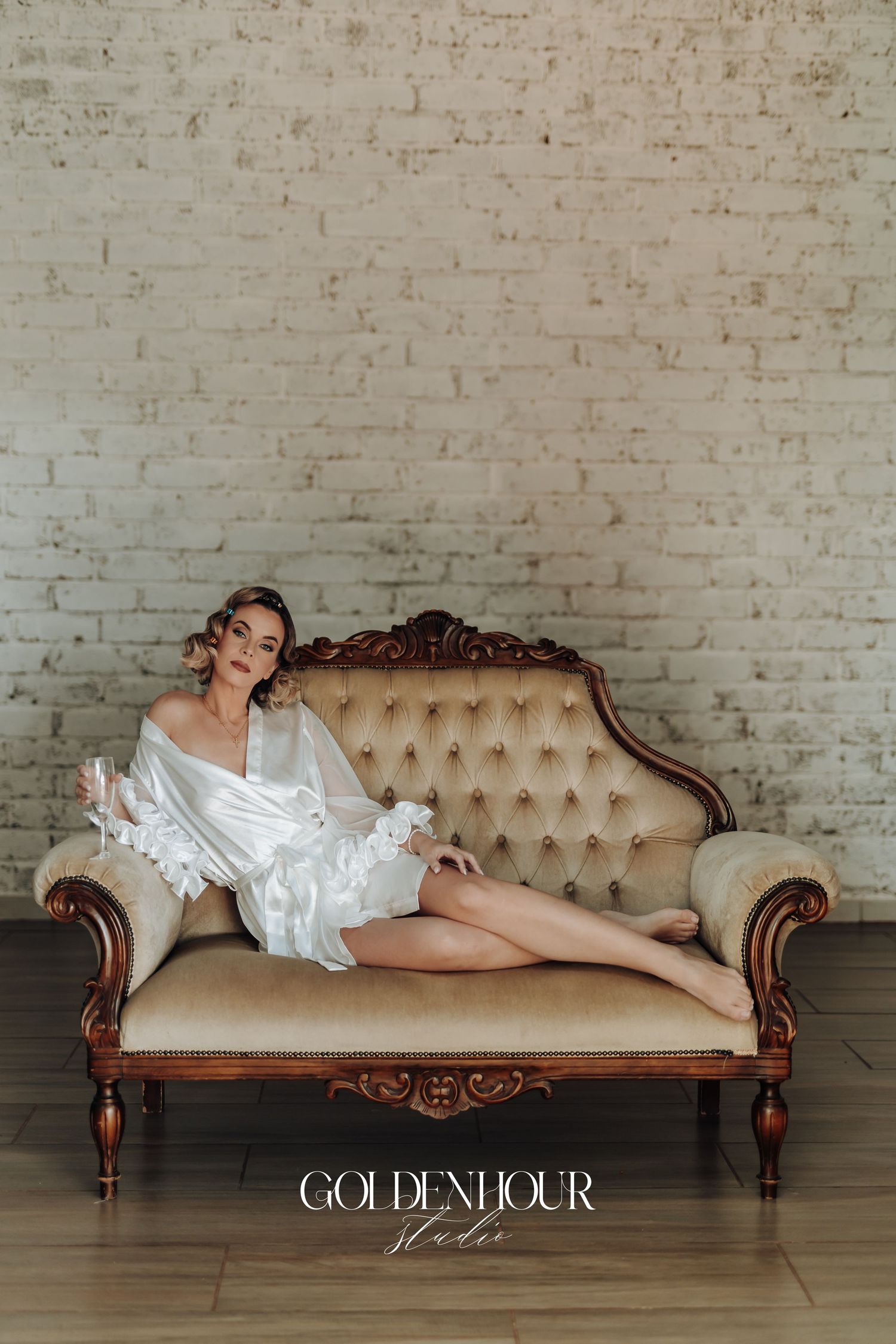 Elegant vintage sofa against white brick wall in studio setting.