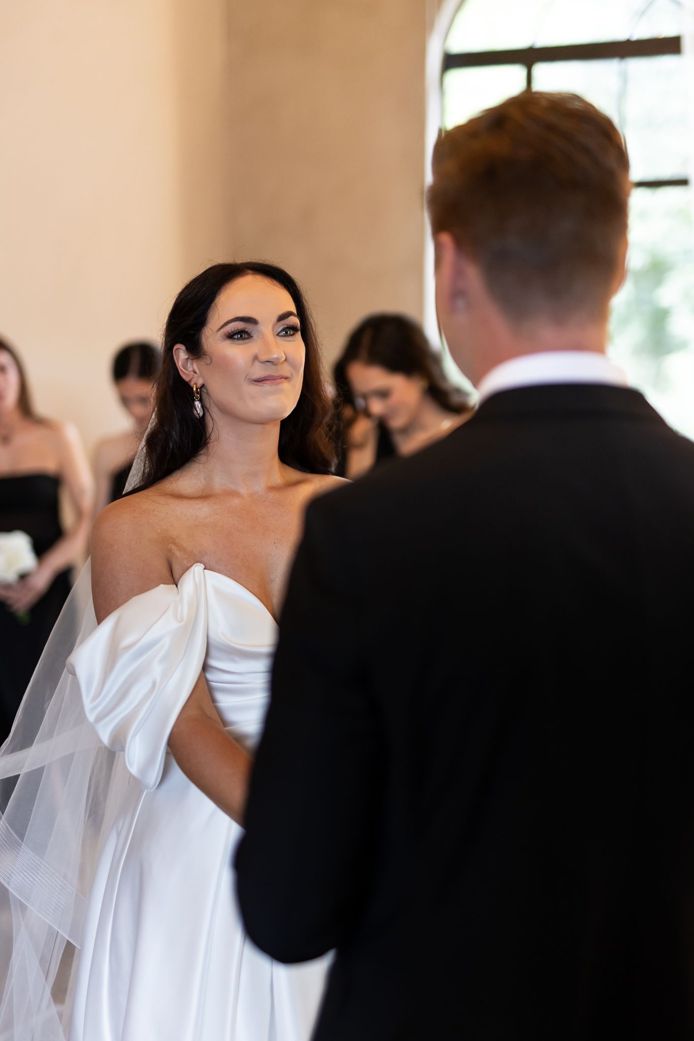 A couple sharing a joyful moment during their wedding ceremony in an elegant indoor setting.