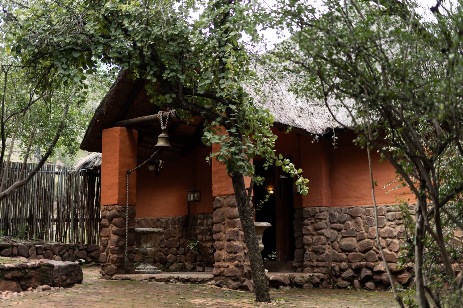A charming stone and wood cabin nestled among green trees and foliage.