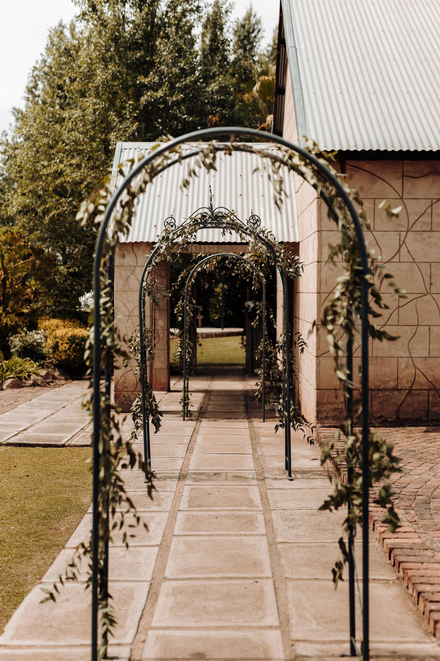 Series of decorative garden arches with greenery creating a beautiful walkway.