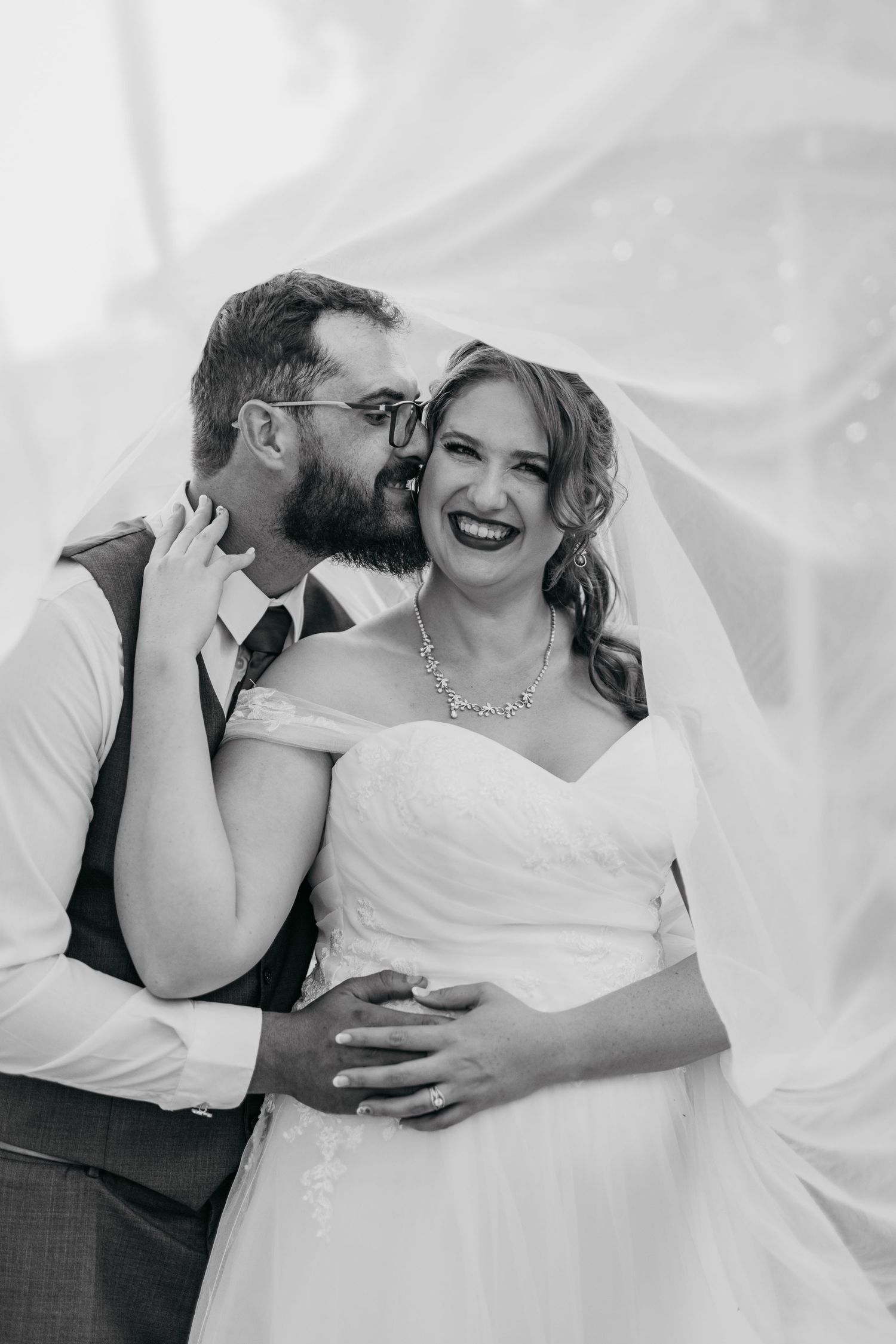 Black and white portrait of a happy wedding couple sharing a tender moment.
