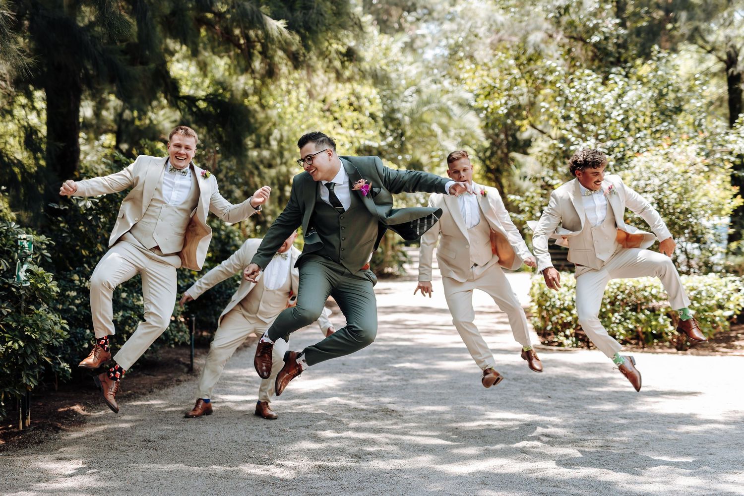 A sequence of playful jumping photos showing people leaping in synchronization on a sunny garden path.
