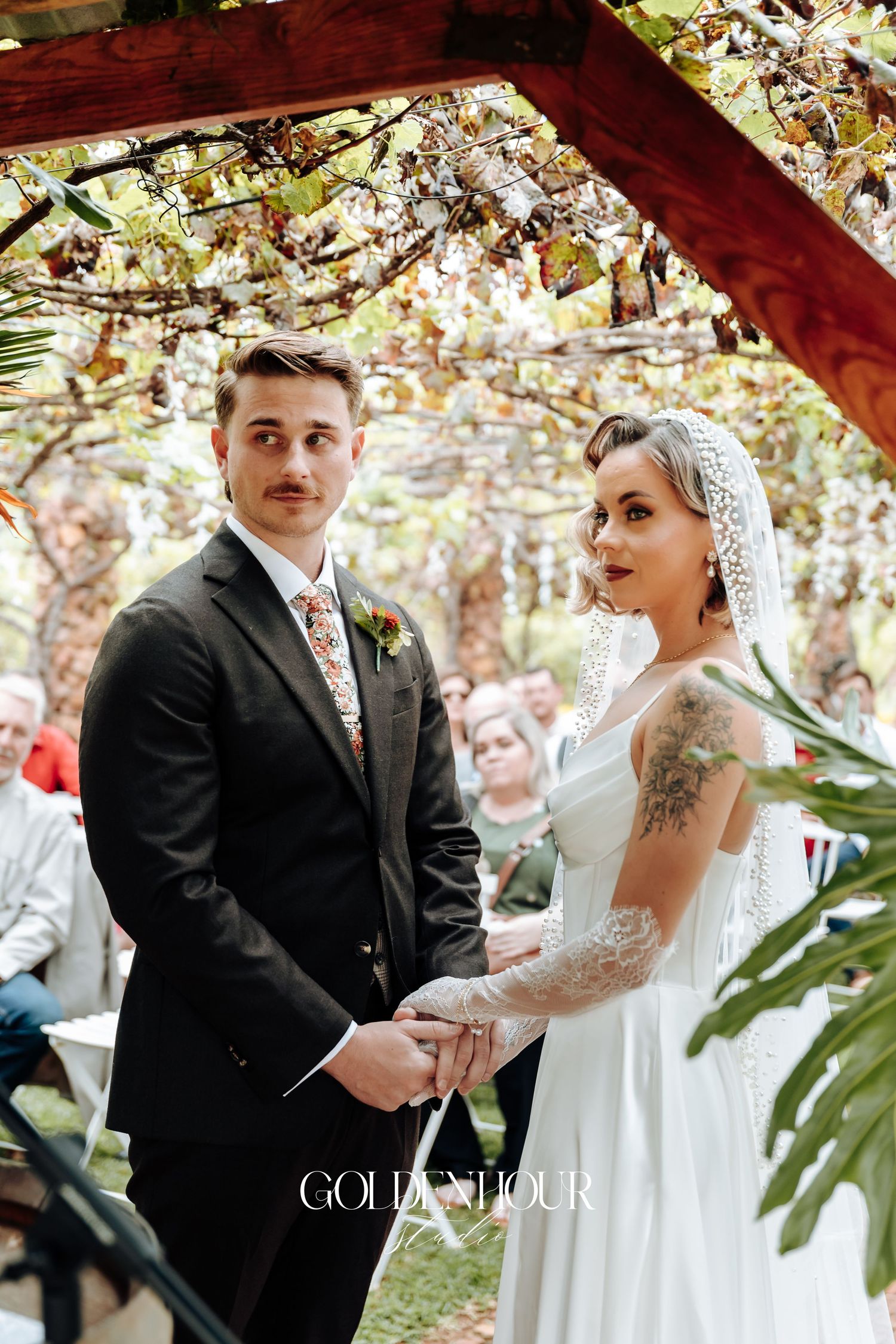 Romantic outdoor wedding ceremony under flowering tree branches and natural light.