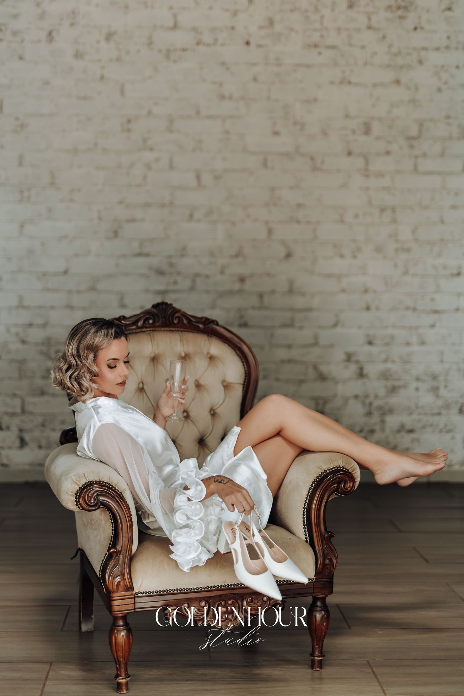 Dramatic boudoir photography with flowing white robe on an antique tufted chaise lounge.