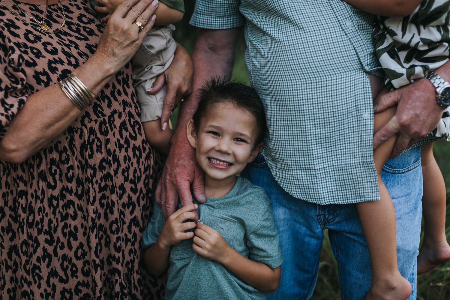A playful family moment captured against a leopard print backdrop showing candid interactions and laughter.