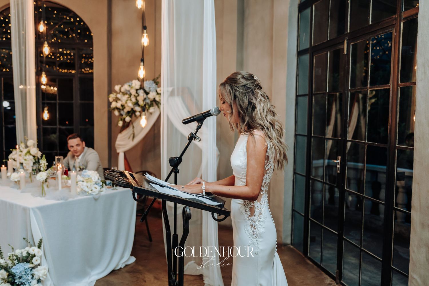 Wedding reception venue decorated with string lights and modern industrial elements creating a romantic atmosphere.