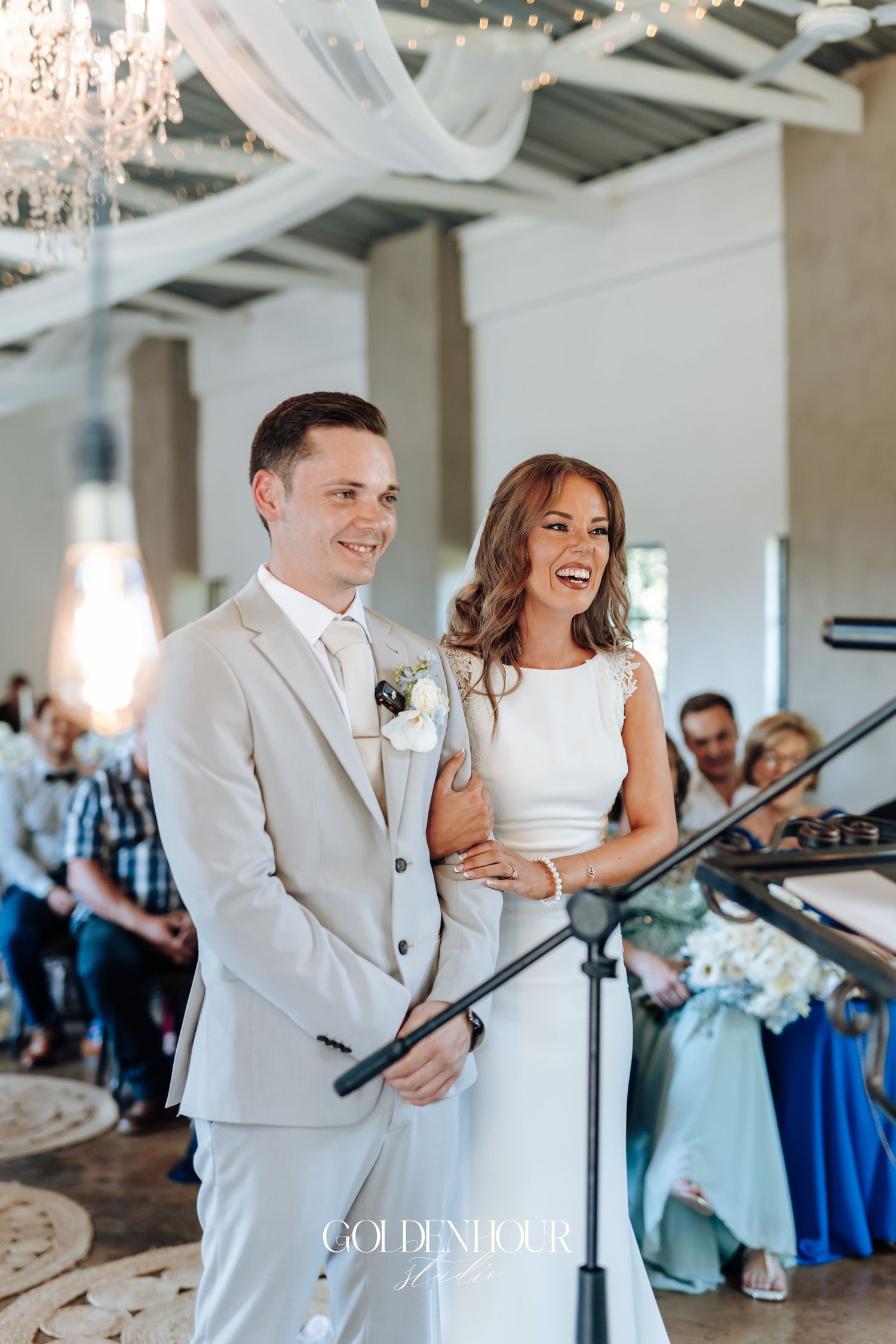 Wedding reception scene with couple sharing a joyful moment at podium.