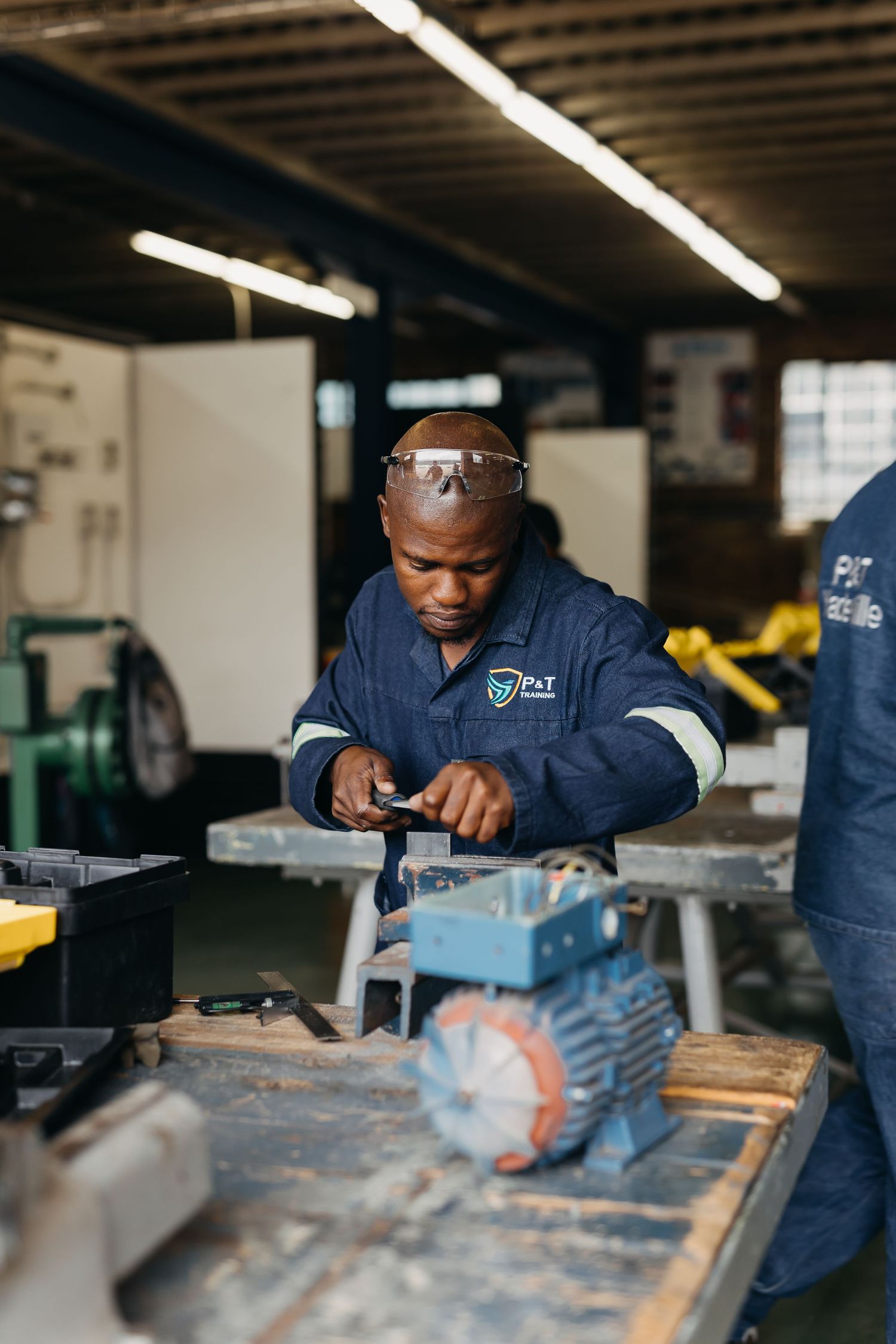 Student in a vocational training class working with industrial machinery at a technical education facility.