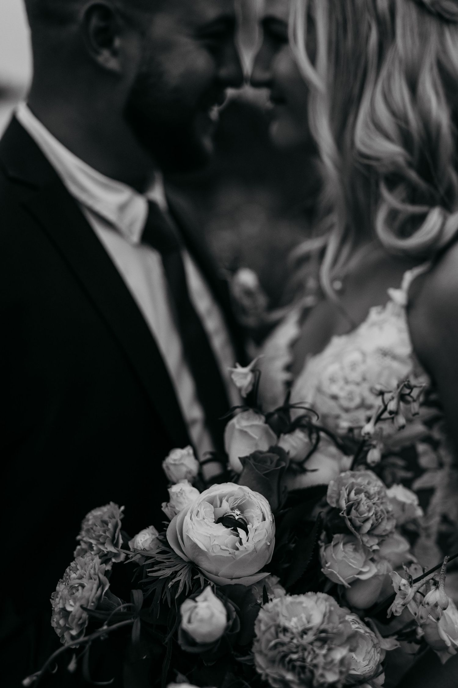 Black and white wedding photo series showing romantic floral arrangements with delicate roses and soft petals.