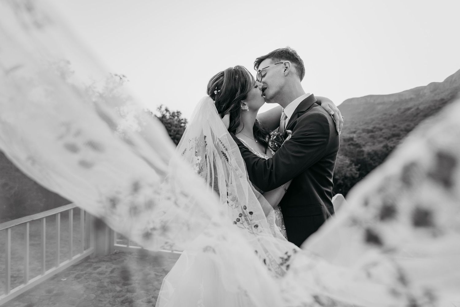 A romantic black and white wedding photo collage showing intimate moments between newlyweds.