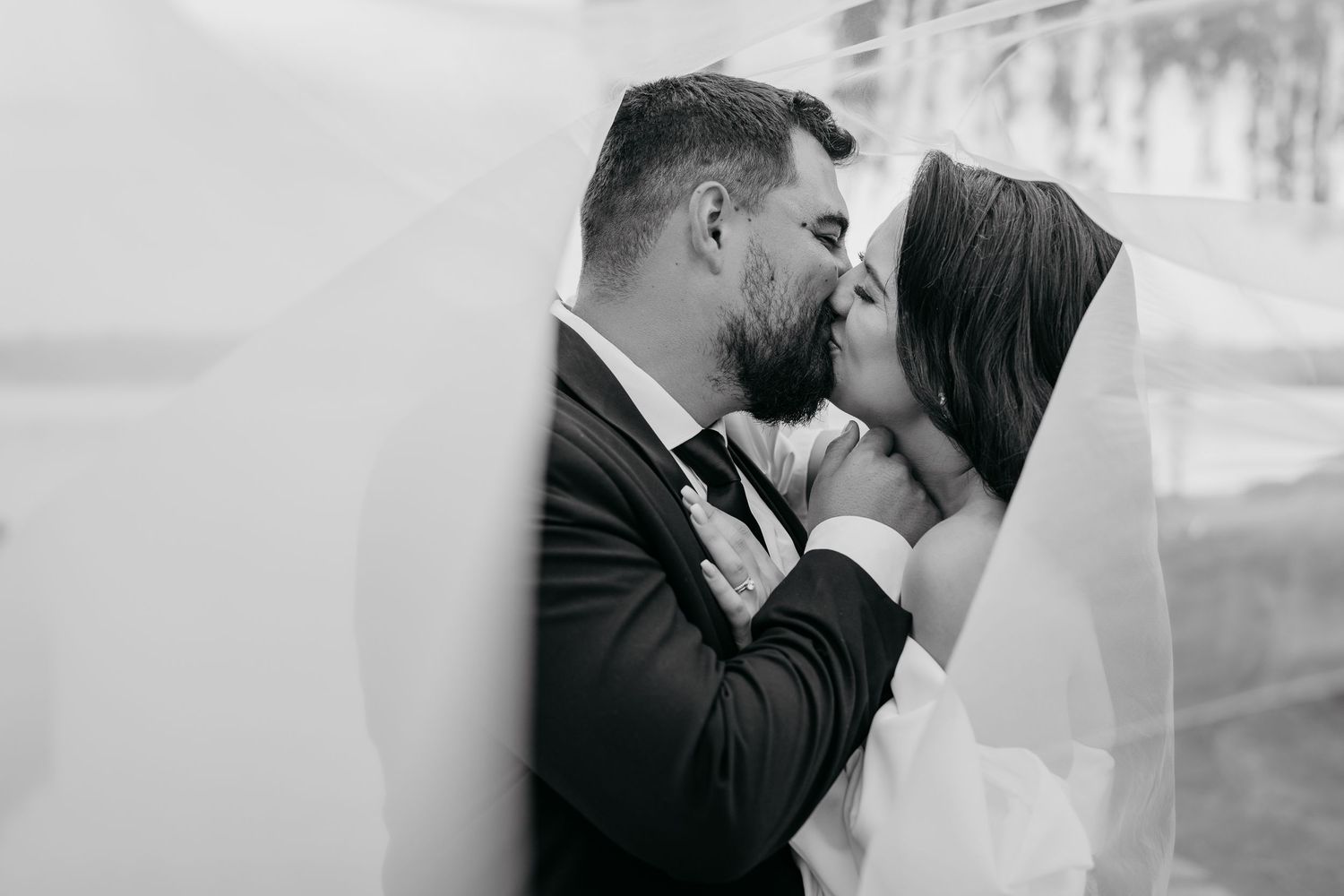 Black and white photo collage of romantic wedding moments showing tender kisses between bride and groom.