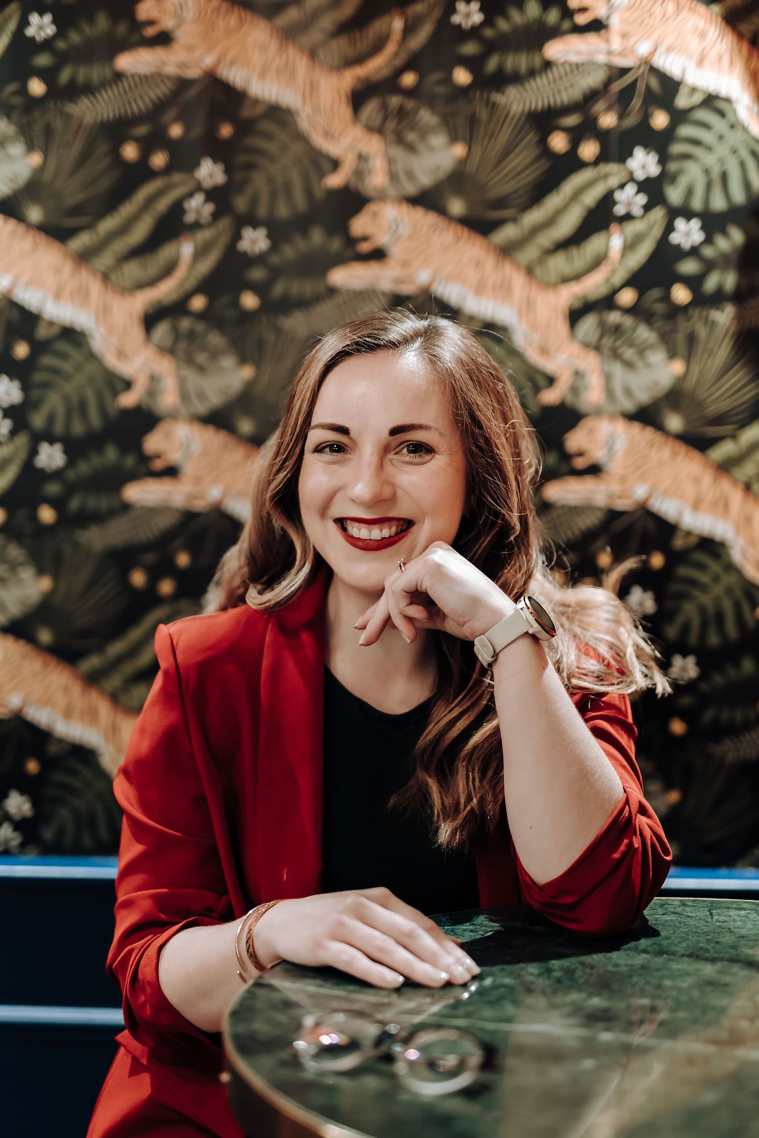 A series of portraits showing a person in a red blazer sitting at a table with festive decorations in the background.