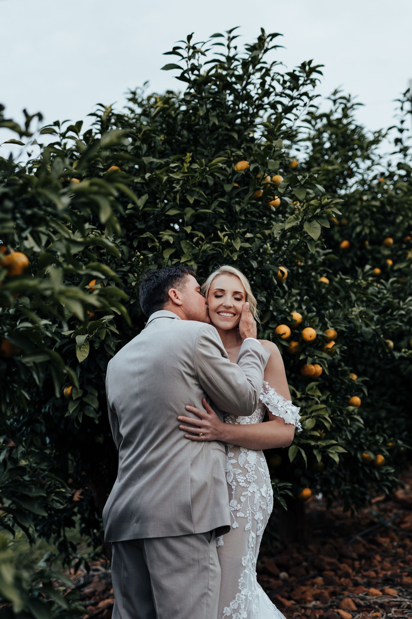Intimate wedding moment captured in a lush citrus grove.