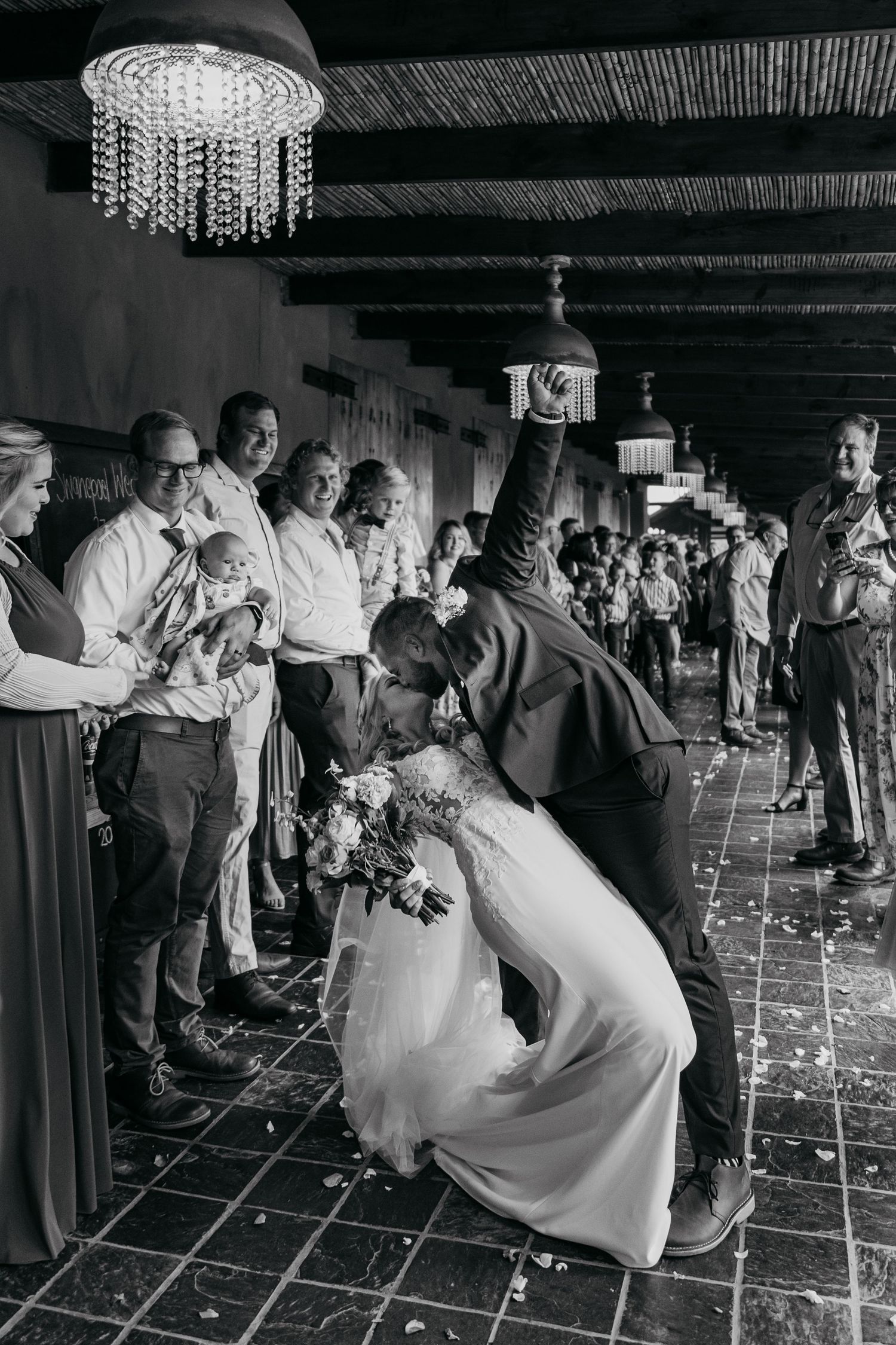 A black and white photo sequence captures couples dancing at an elegant wedding reception under crystal chandeliers.