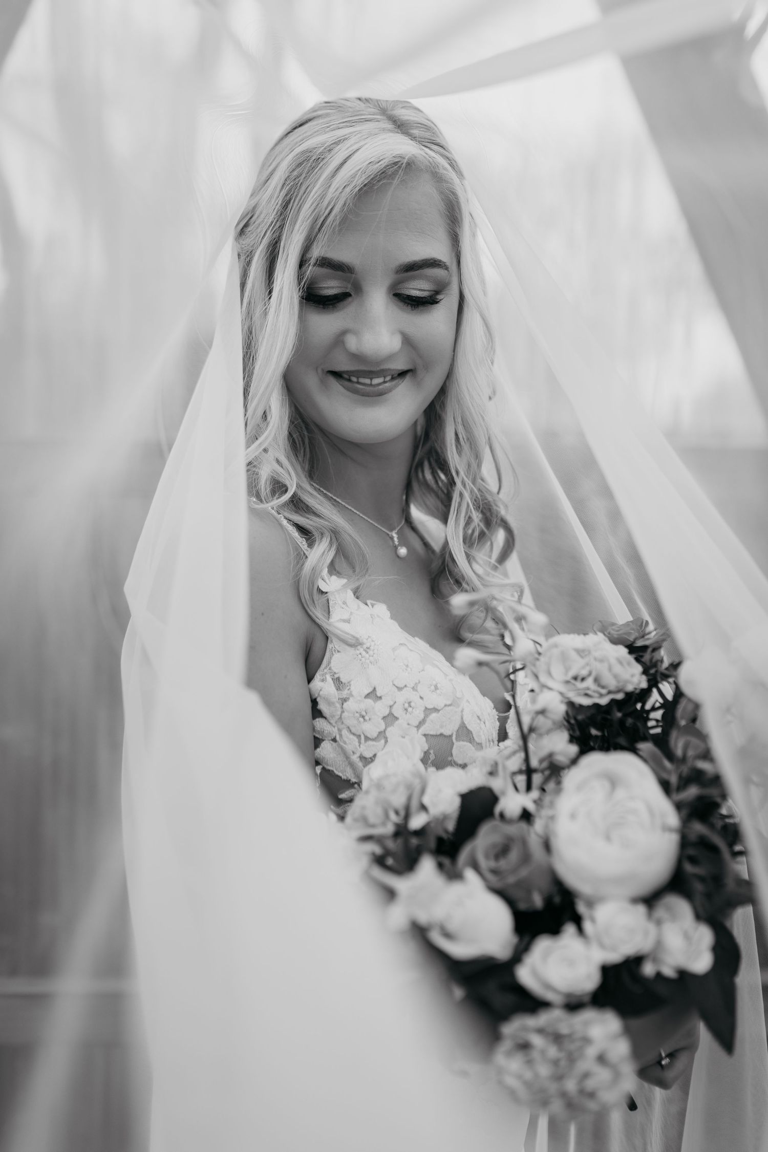 Black and white wedding photo series showing a bride in a lace dress holding a beautiful floral bouquet.
