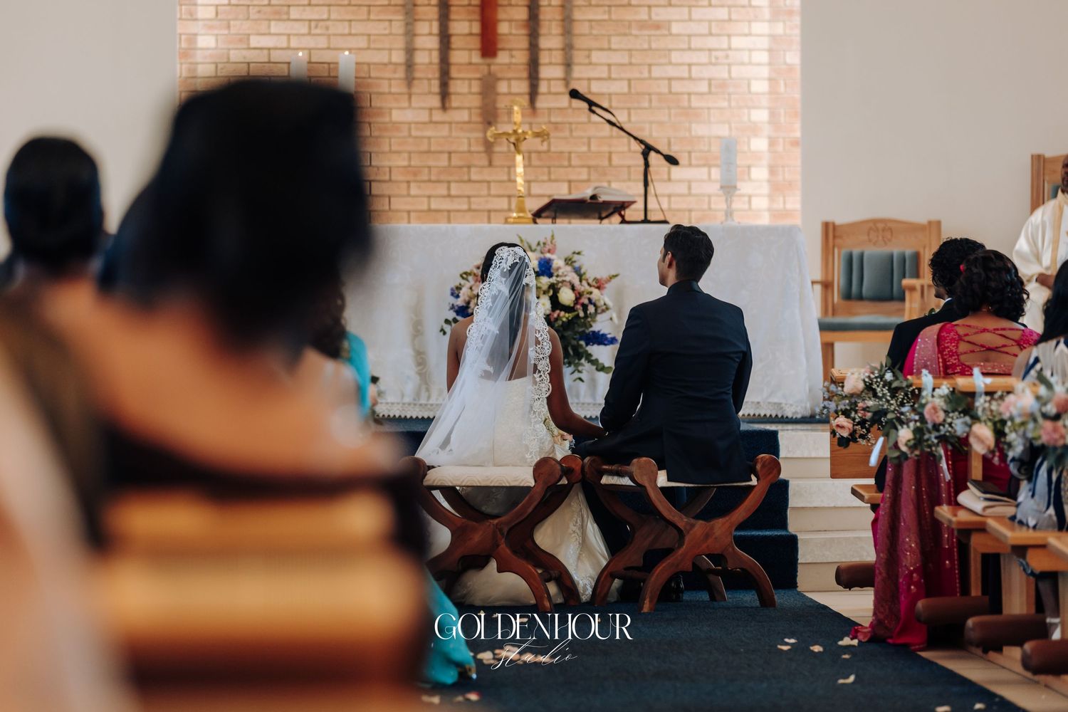 Interior view of a rustic brick-walled venue with wooden chairs set up for a ceremony.