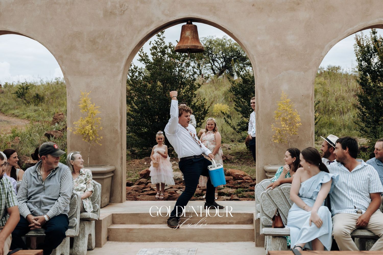 Wedding celebration candid moments under stone archways at an outdoor venue.