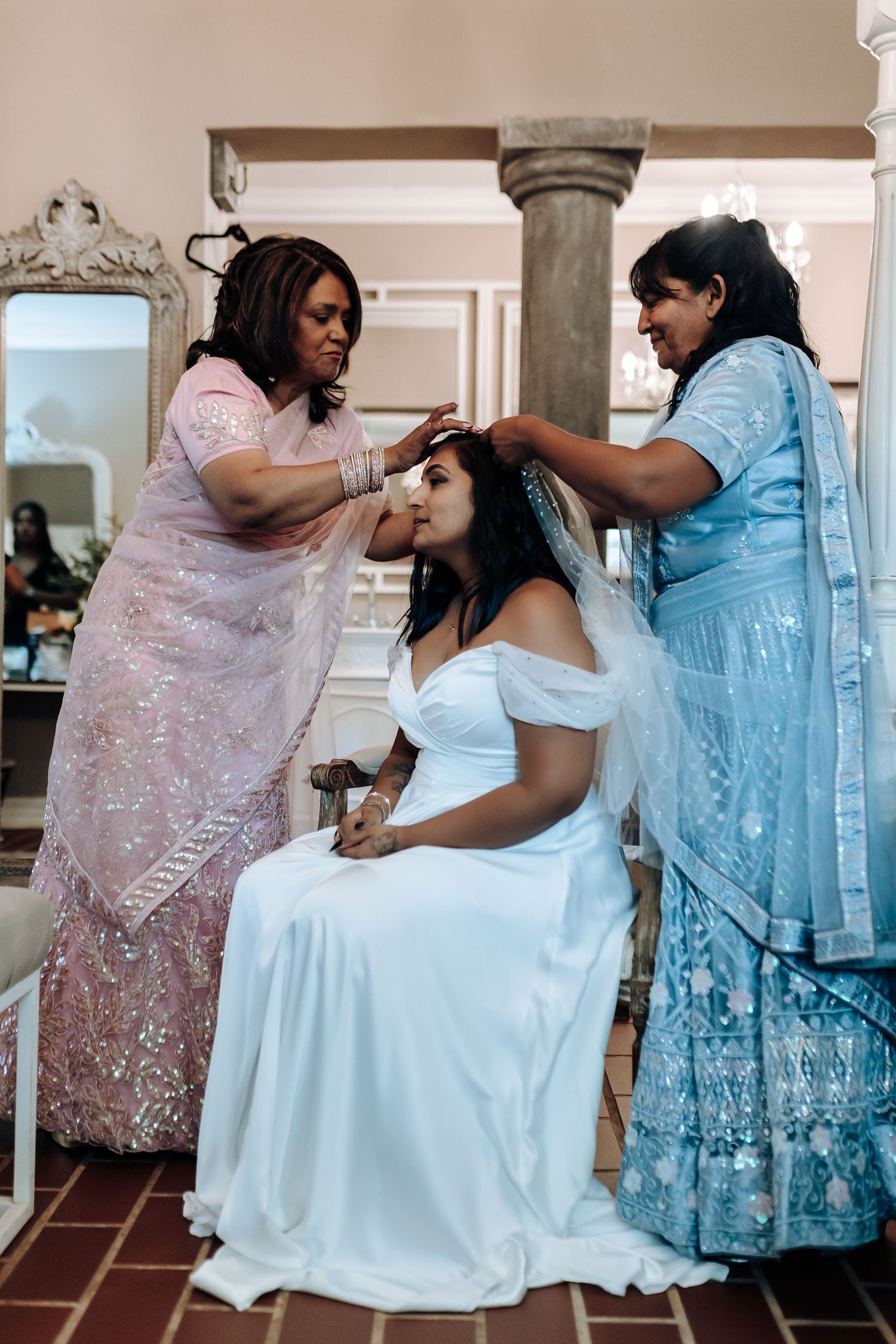 Wedding preparation scene showing styling session in an elegant room with ornate columns.