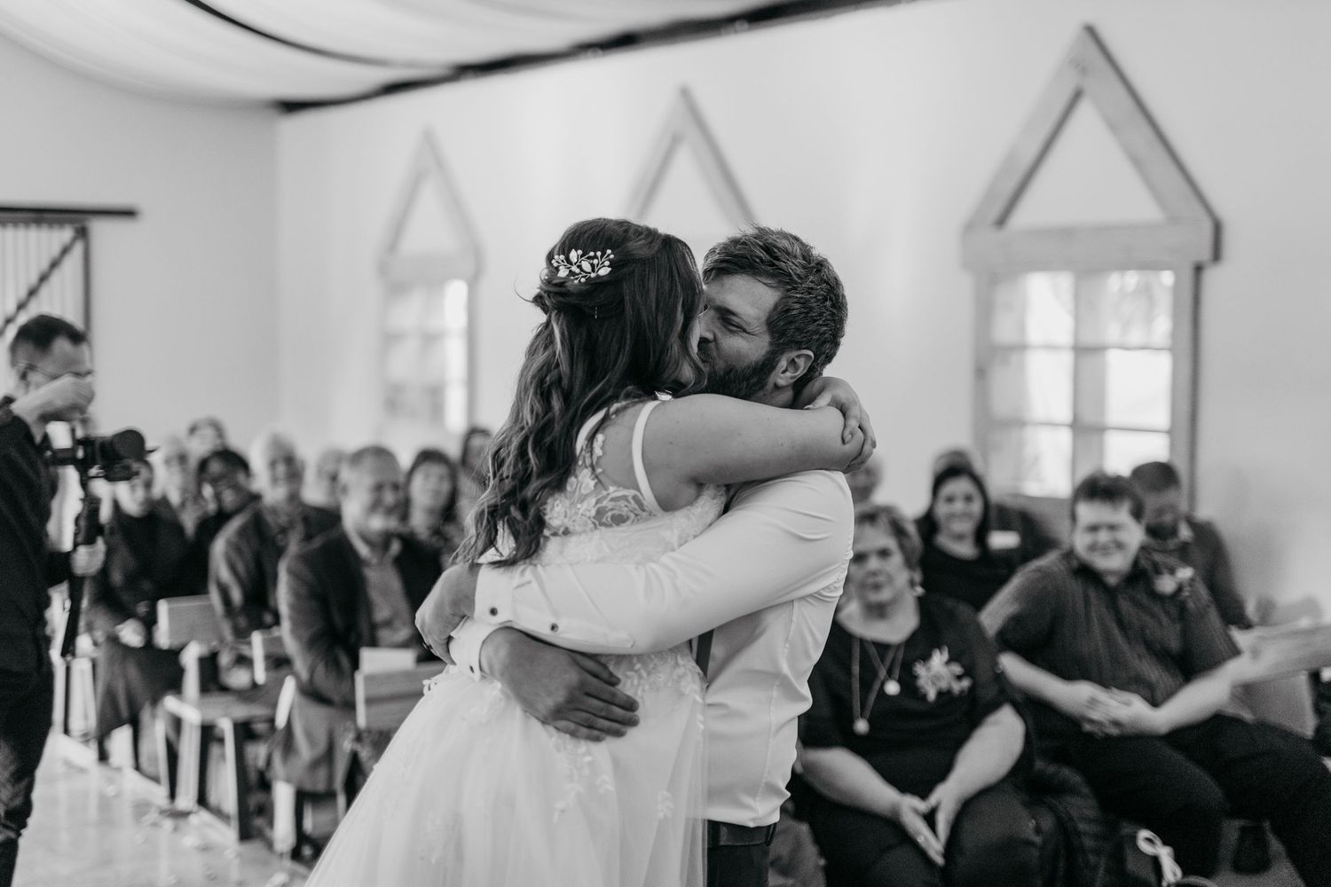 Black and white capture of an emotional wedding embrace during ceremony.