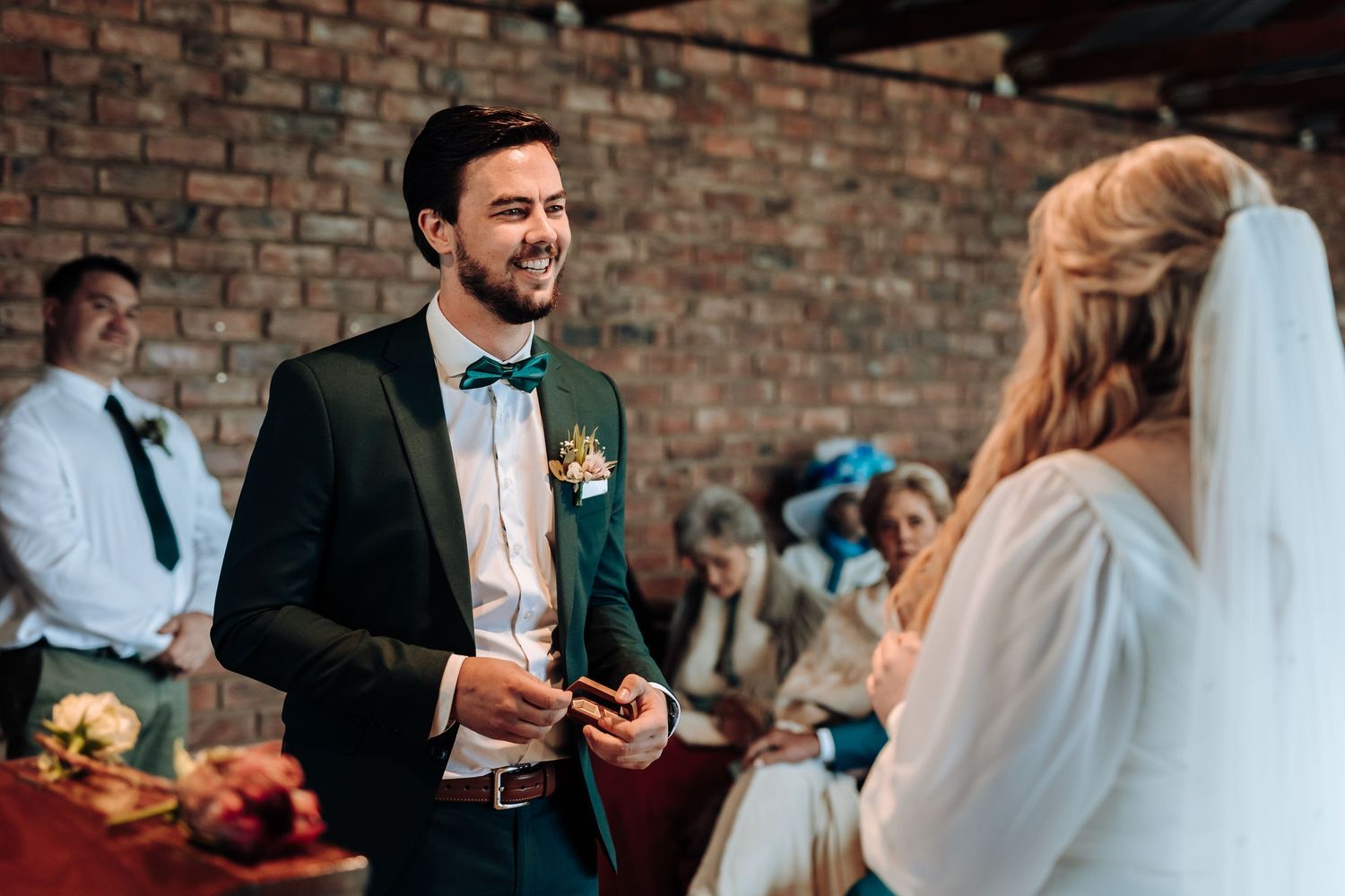 Couple shares a joyful moment during their wedding ceremony in an industrial-style venue.
