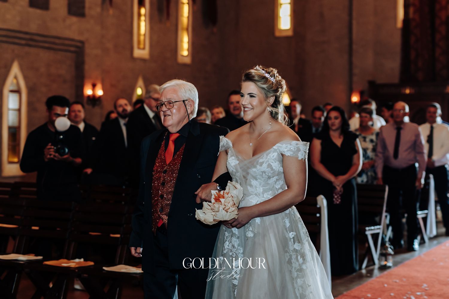 Bride walking down the church aisle with her father during a traditional wedding ceremony.