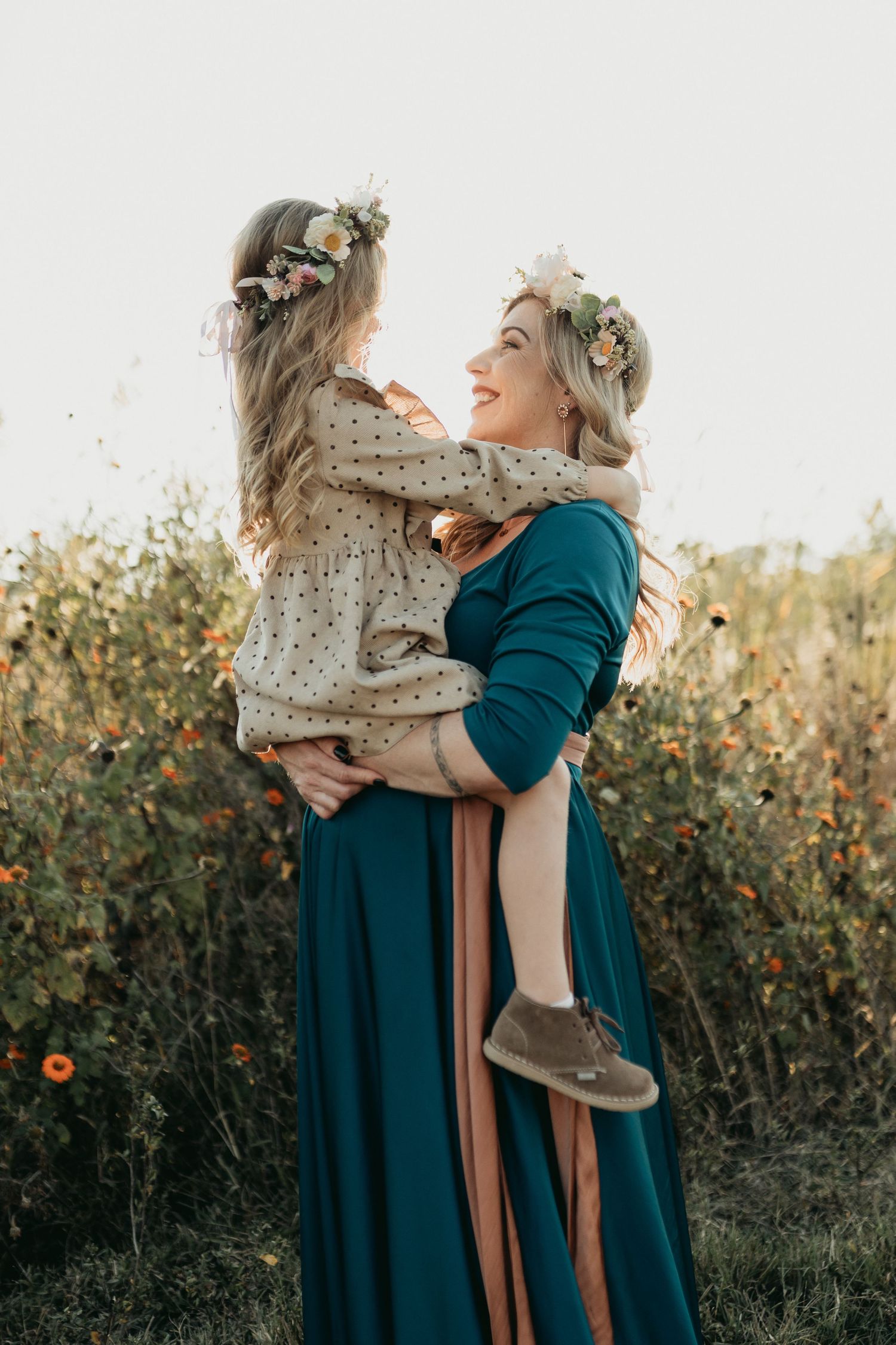 Heartwarming outdoor portrait showing playful interaction in matching teal and floral outfits.