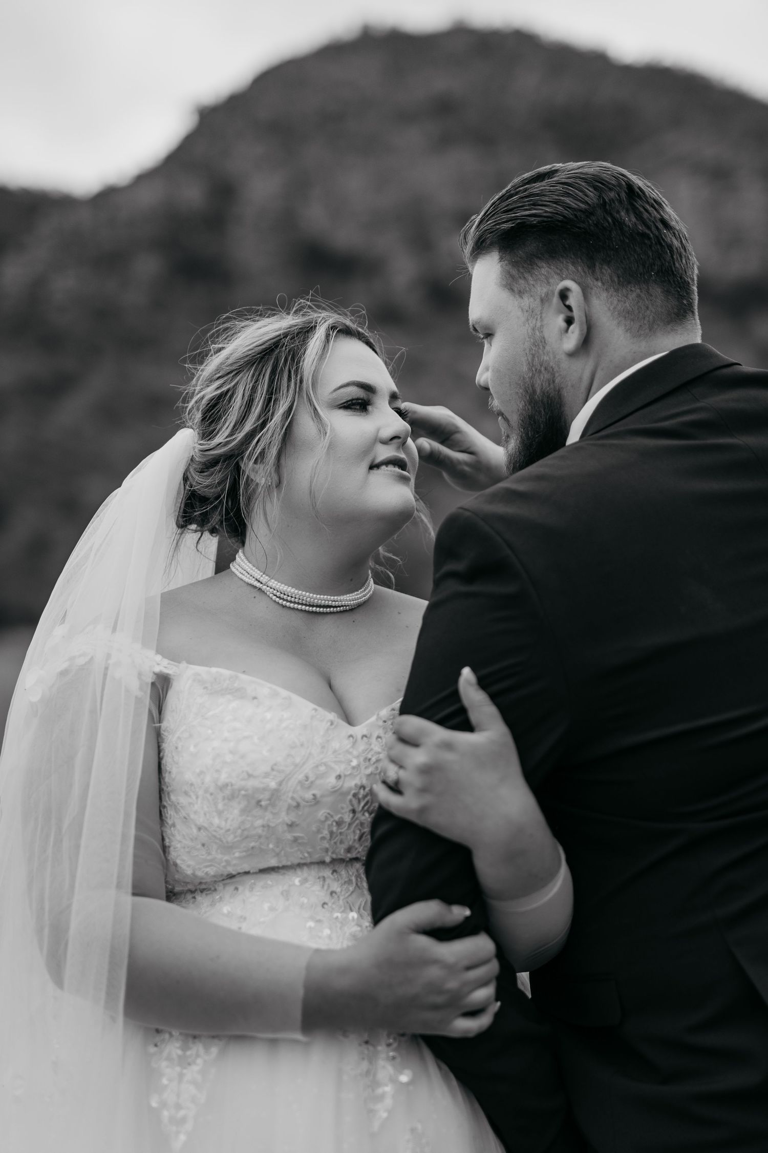 A sequence of black and white wedding photos showing tender moments between a couple in formal wedding attire.