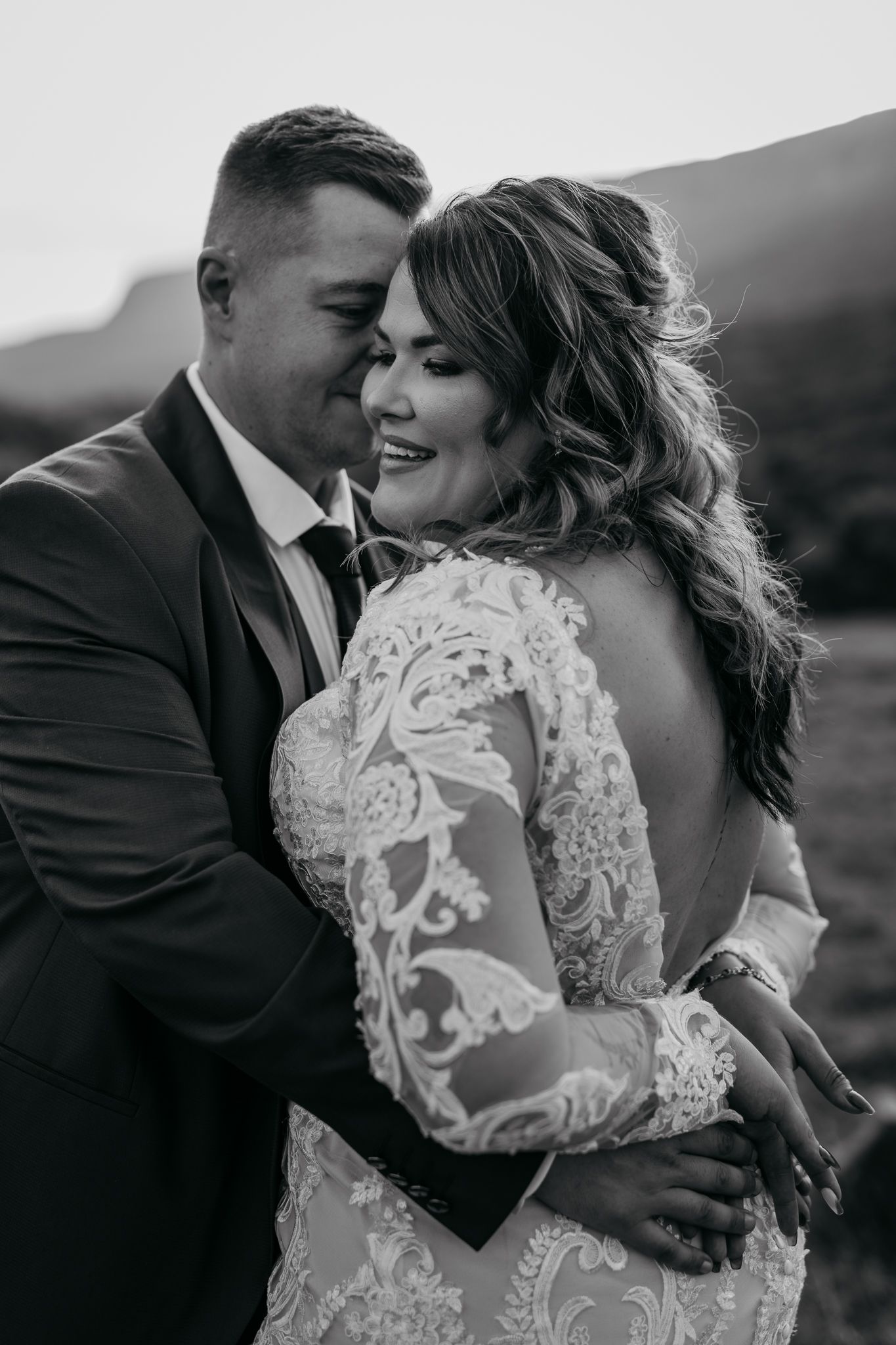 Intimate black and white wedding portrait showing tender moment between newlyweds.