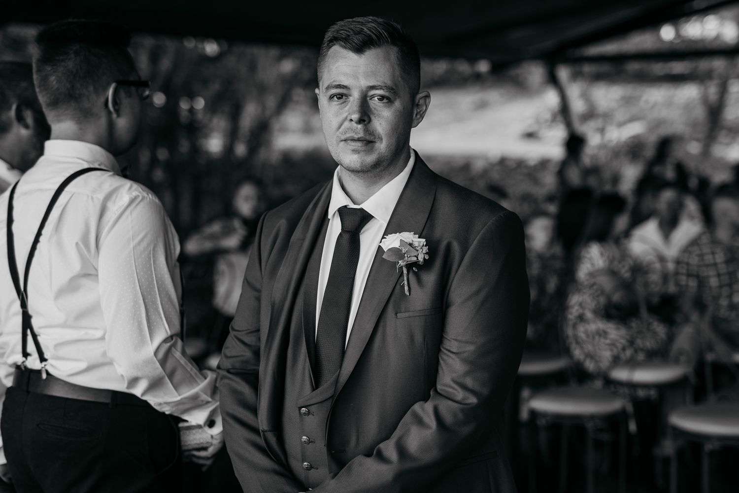 Black and white photo of formal wedding attire at outdoor ceremony venue.