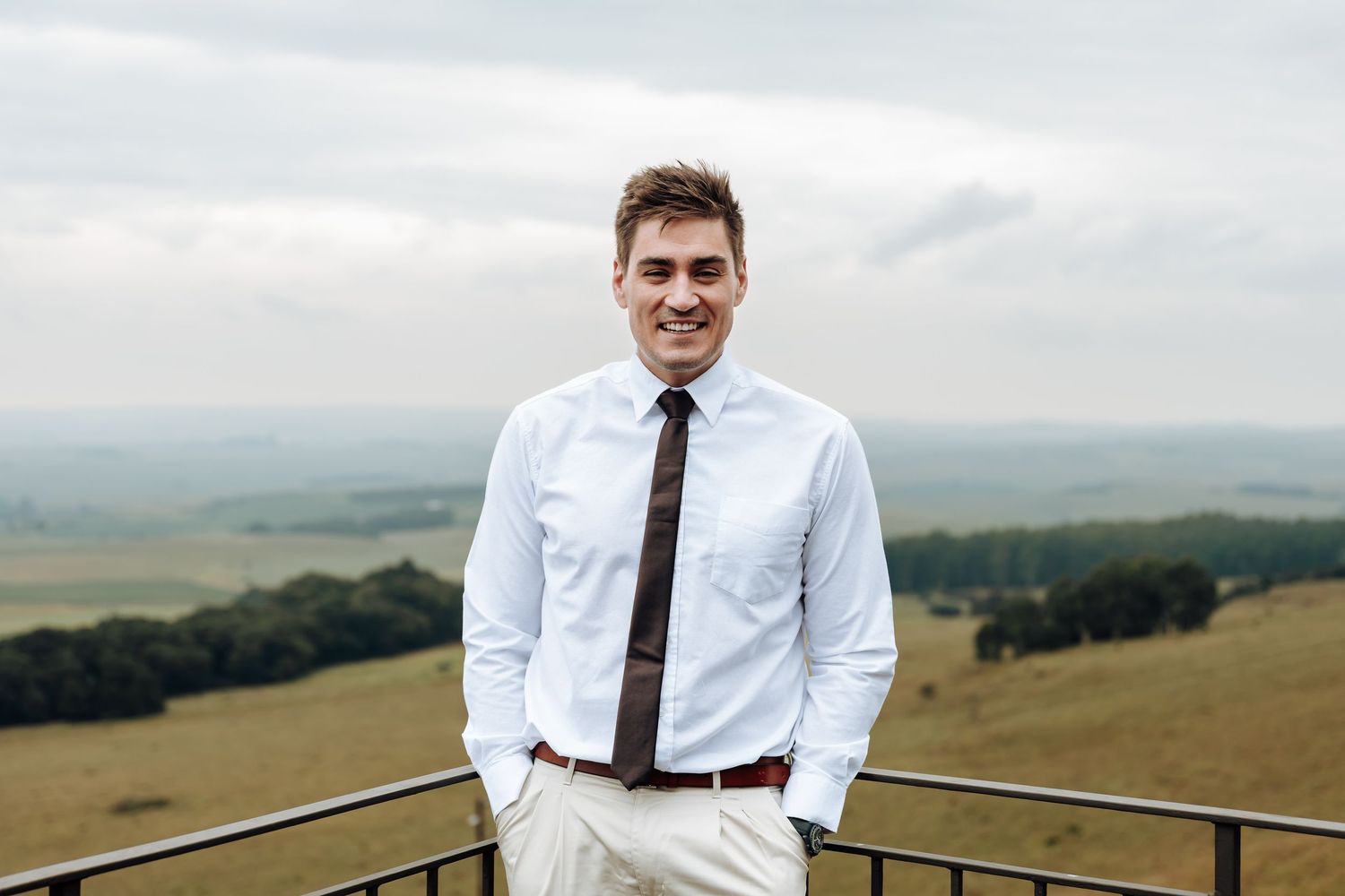 A scenic outdoor photoshoot in rolling green hills with mountains in the background.