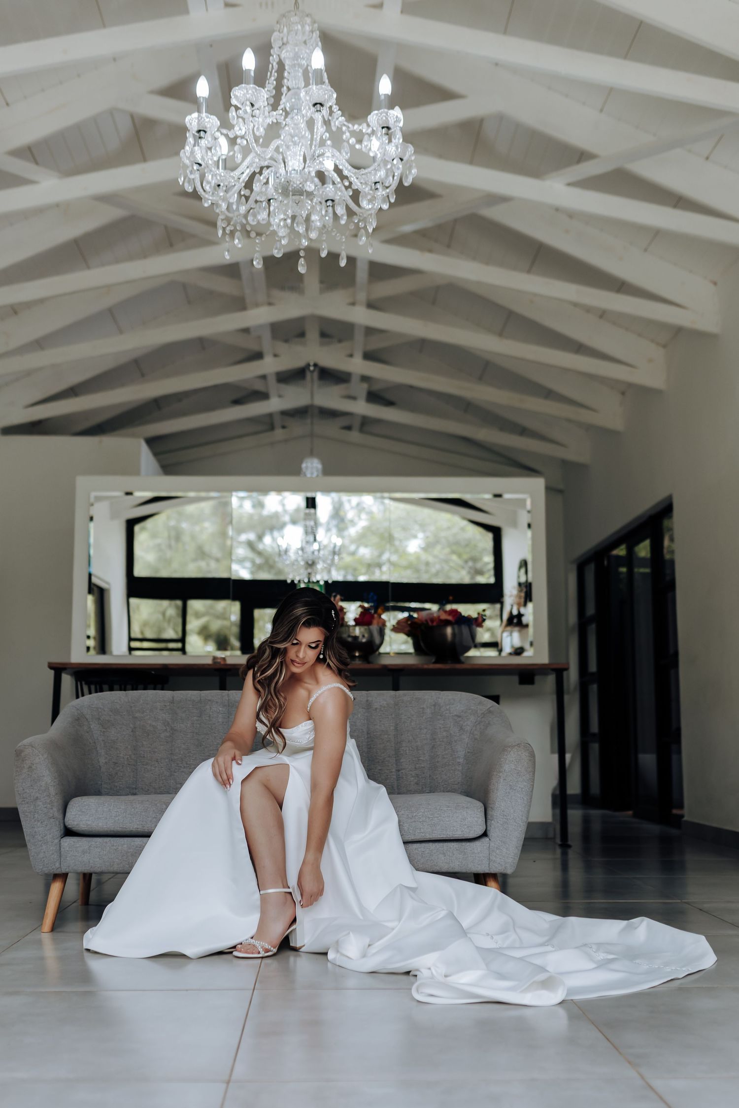 A luxurious room with white vaulted ceilings, crystal chandeliers, and elegant furnishings sets a romantic scene.