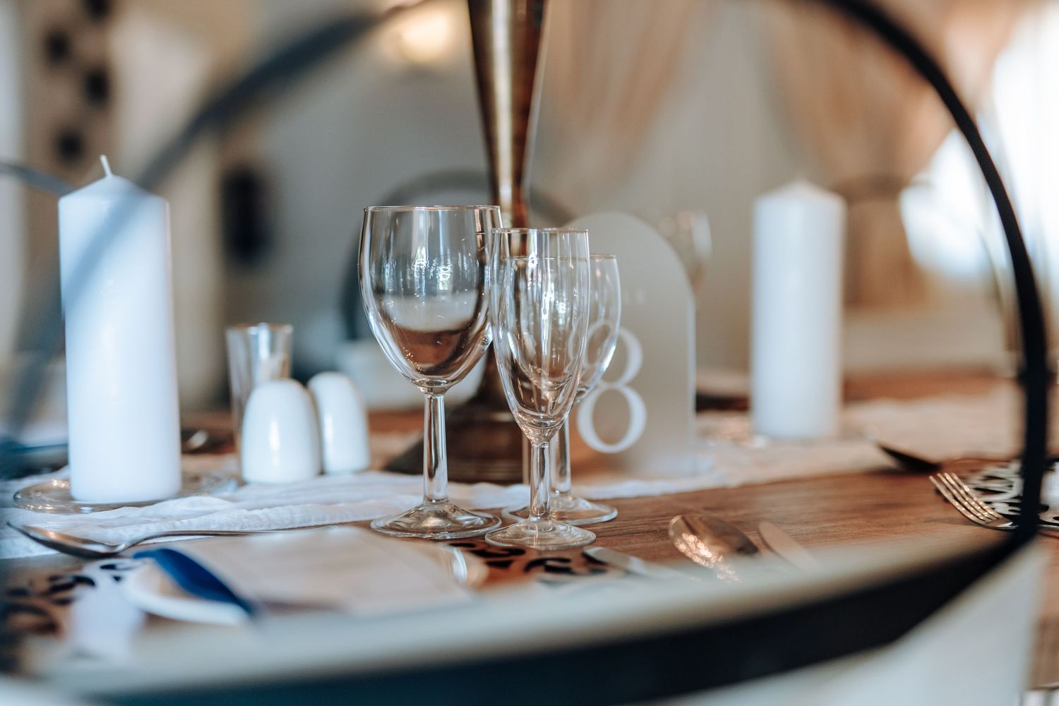 Elegant table settings with wine glasses and white linens in an upscale restaurant dining room.