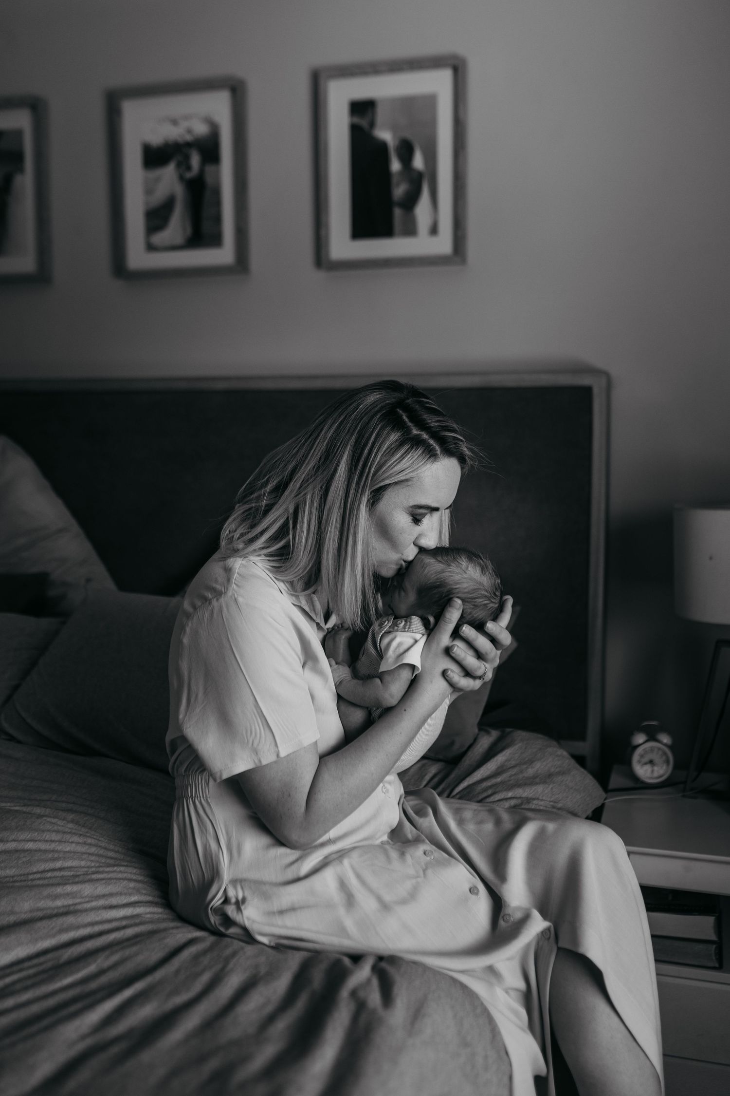 A series of black and white photographs showing intimate family bonding moments in a bedroom setting.