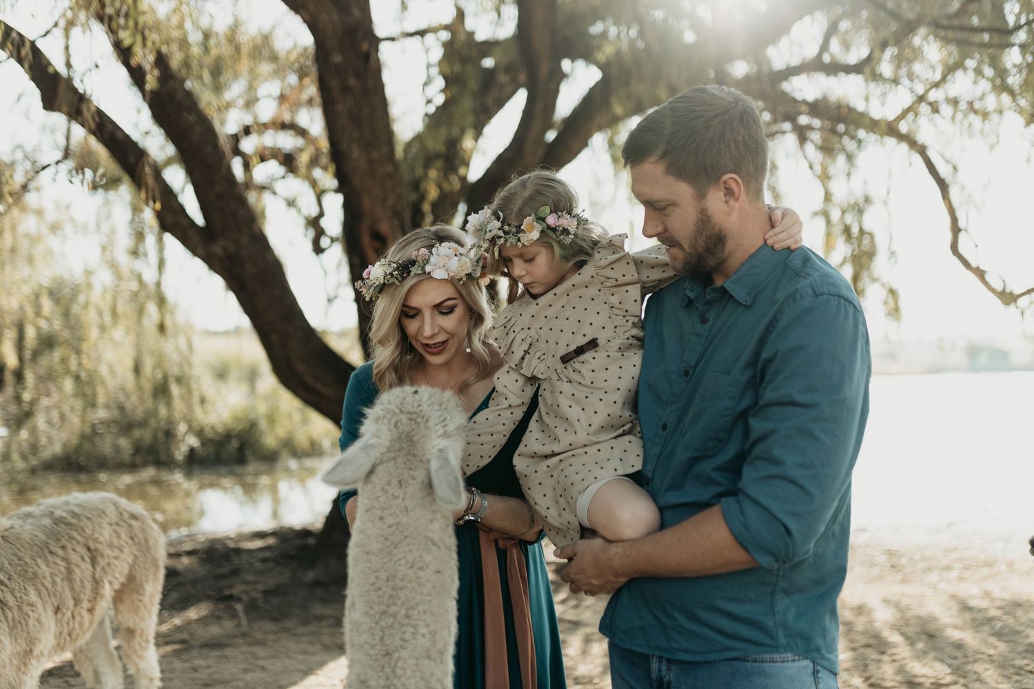 Romantic outdoor golden hour photo session under Spanish moss draped trees near the water.