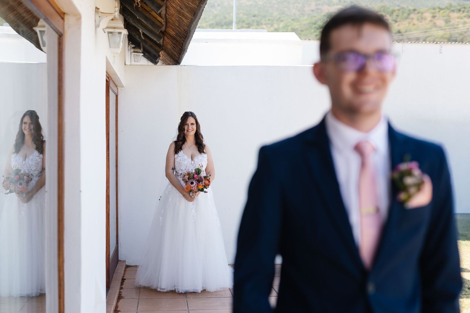 Wedding party members in formal attire stand together during an elegant indoor celebration.