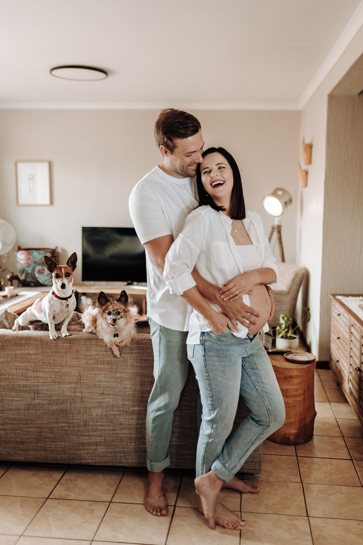 Candid sequence of a couple dancing and playing with their dog in a modern living room.