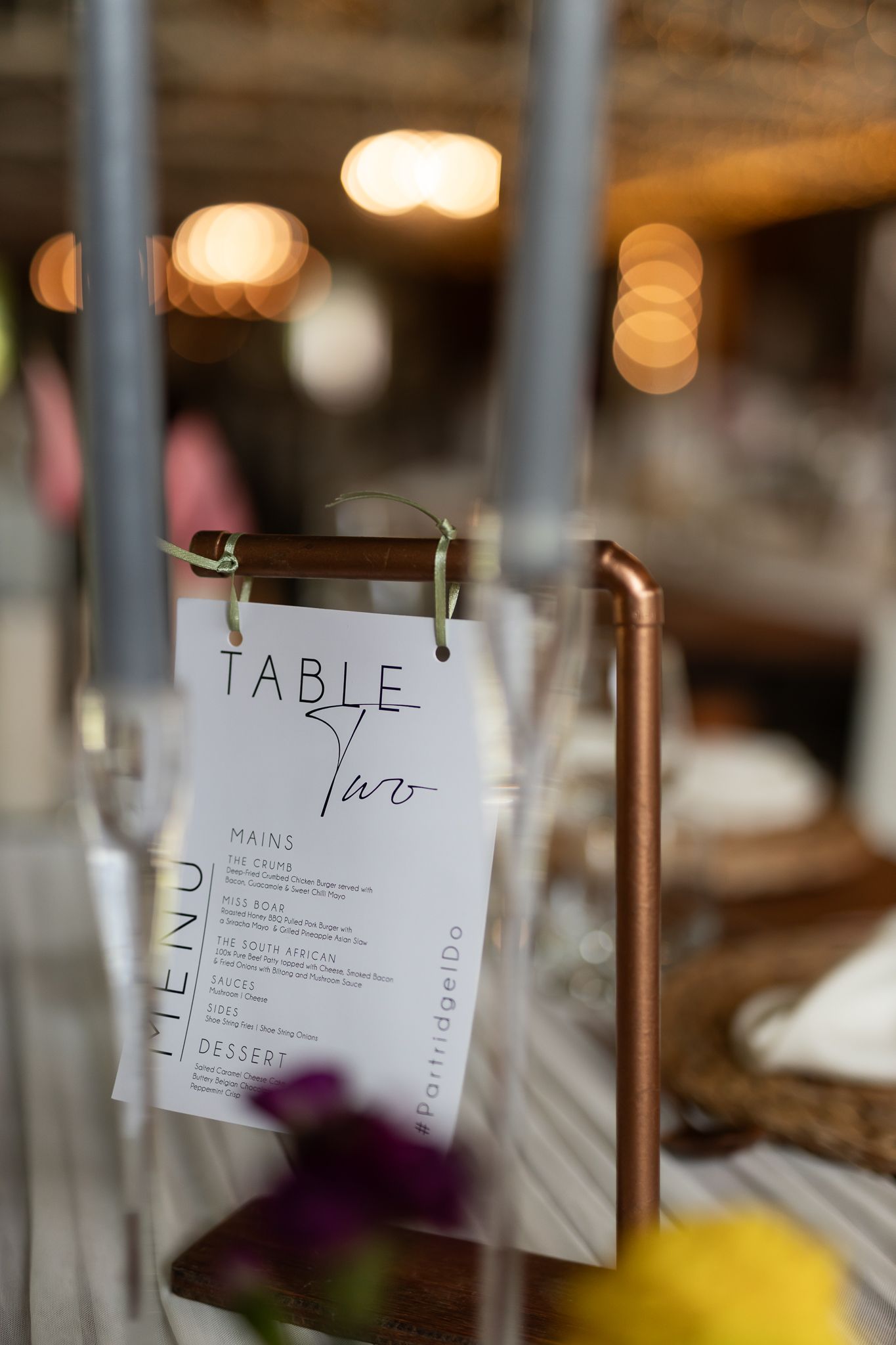 Modern table number display with minimalist design in an industrial wedding setting.