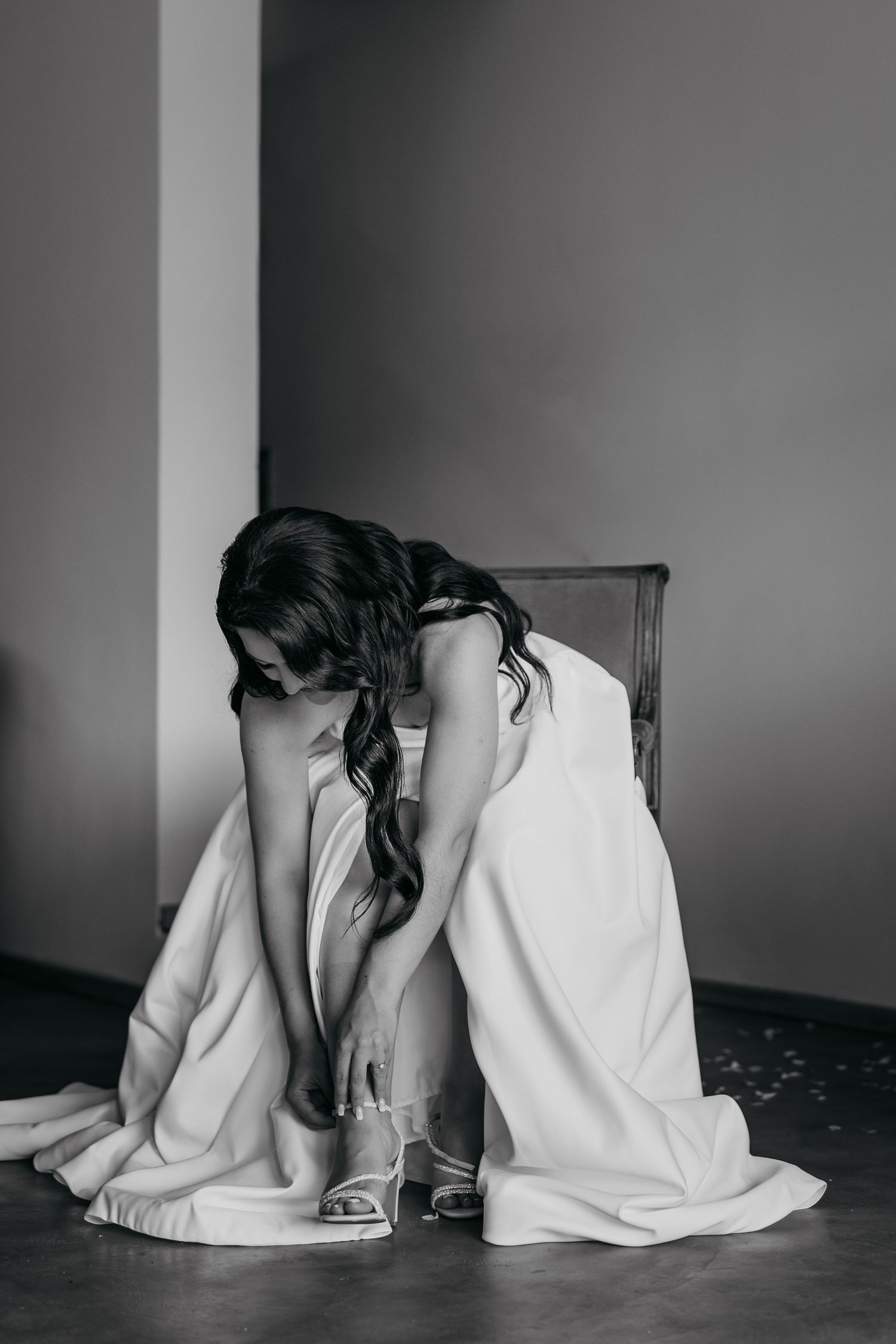 Black and white photo series showing two people sitting back to back on the floor against a wall.