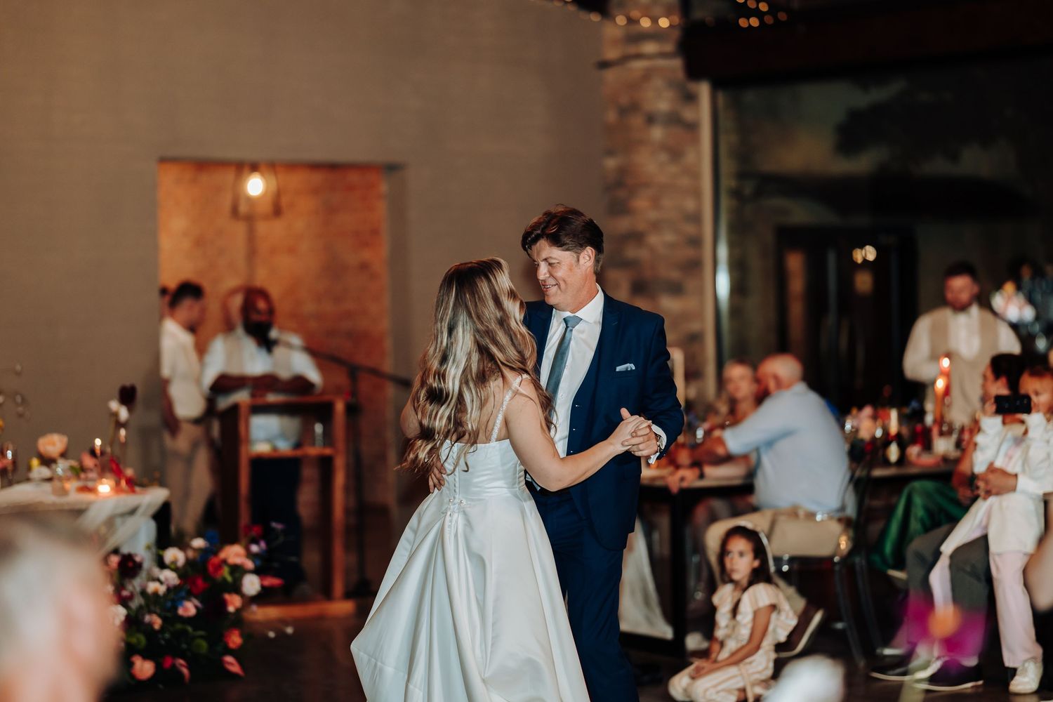 A couple shares their first dance at their wedding reception in an elegant venue.