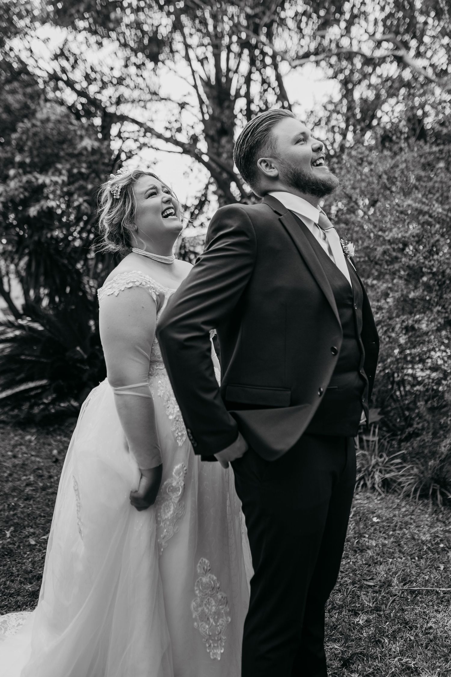 Black and white photo sequence of newlyweds laughing together outdoors during their wedding day photo session.