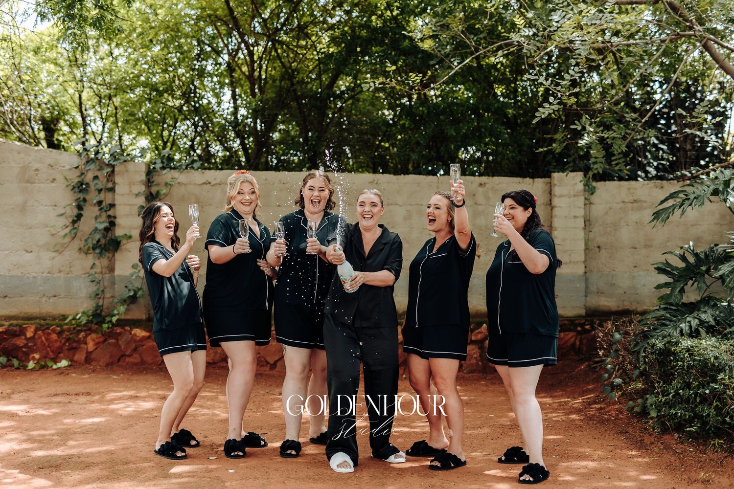 A group of people in black outfits perform a synchronized dance routine in an outdoor setting.
