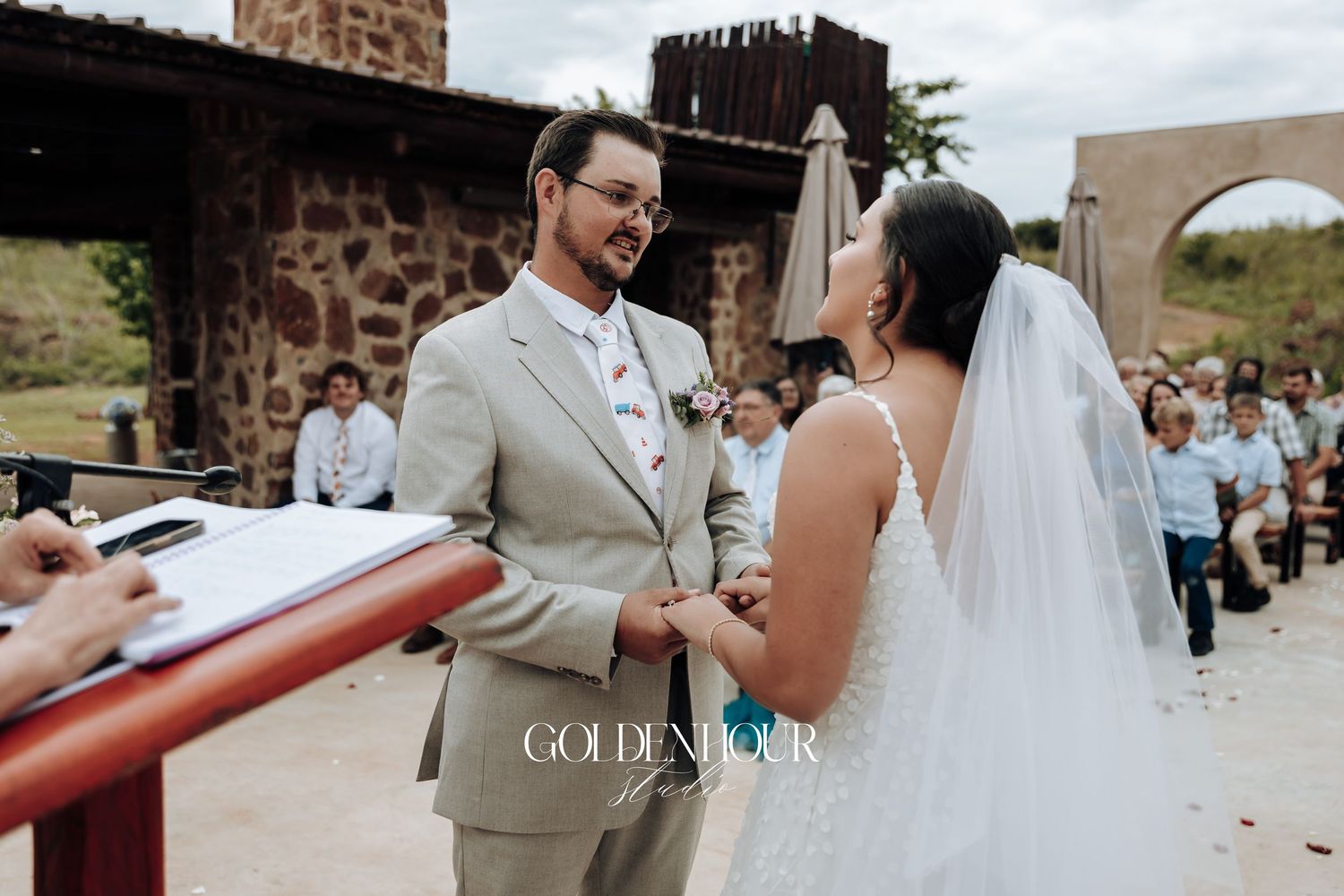Wedding ceremony moments captured under stone archways with guests looking on.