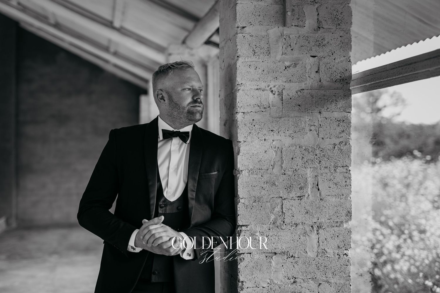 Classic black and white formal portraits against rustic stone wall backdrop.