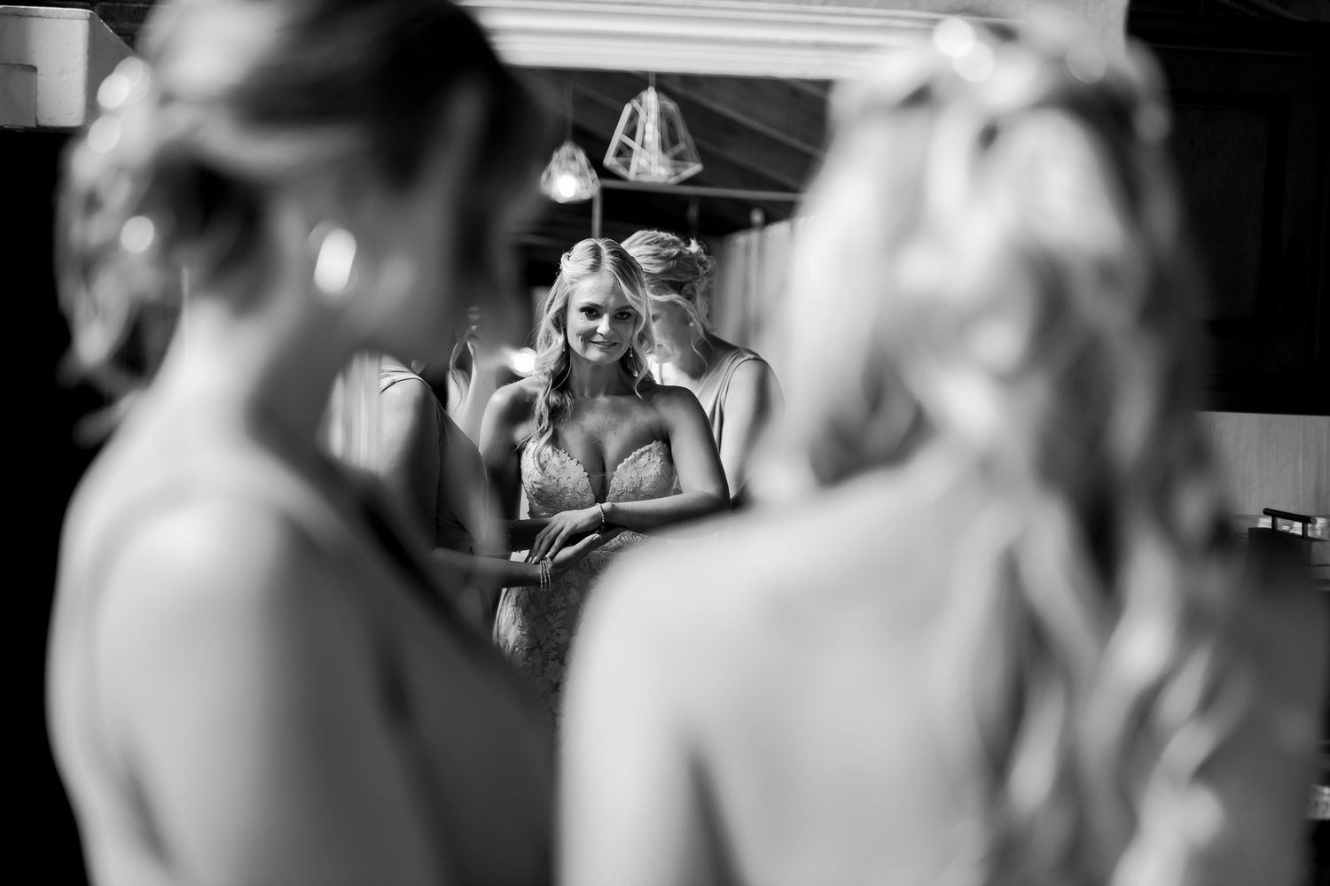 Black and white reflection of wedding preparations in a dressing room mirror.