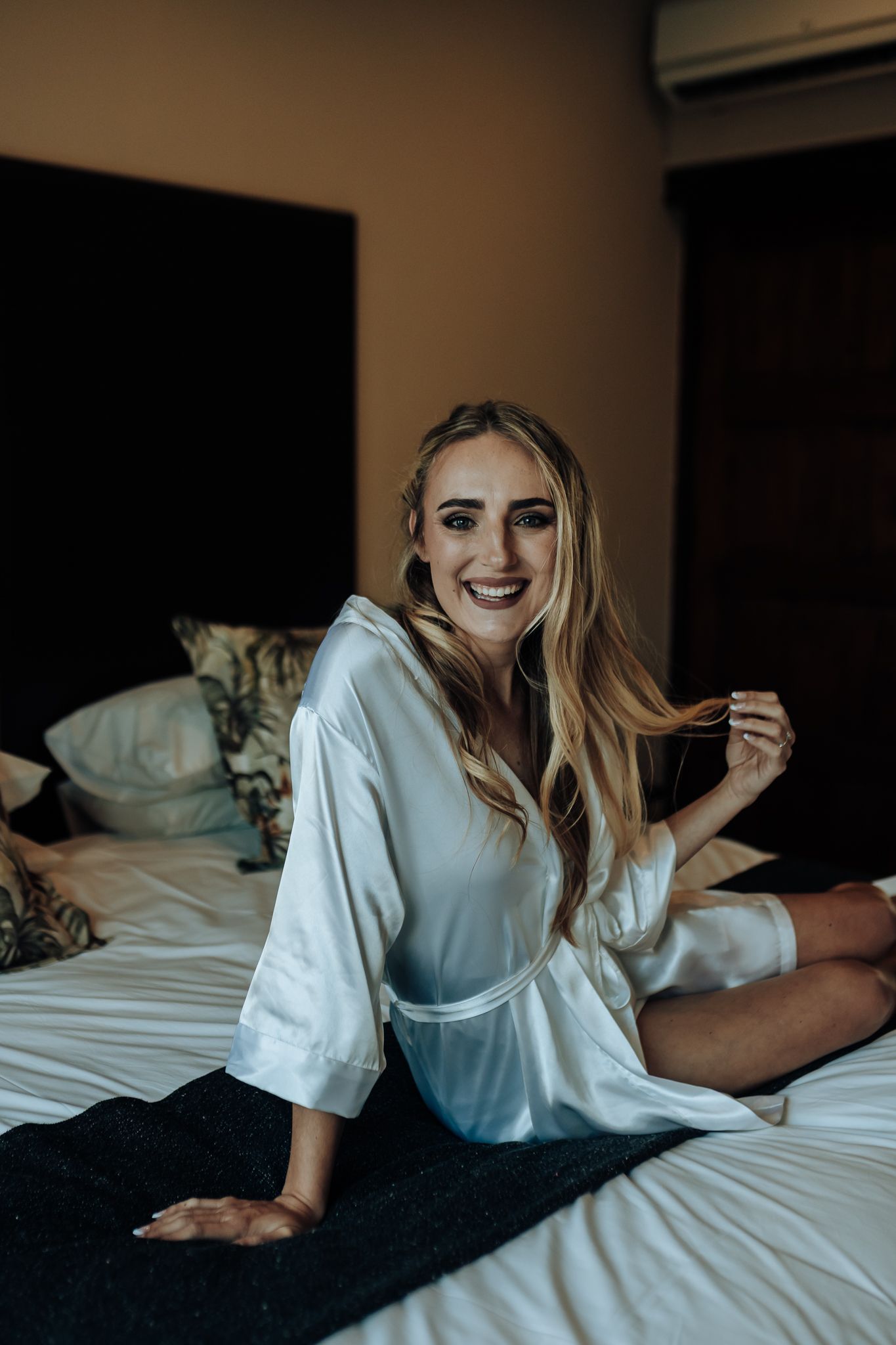 Candid getting ready moment captured in natural window light.