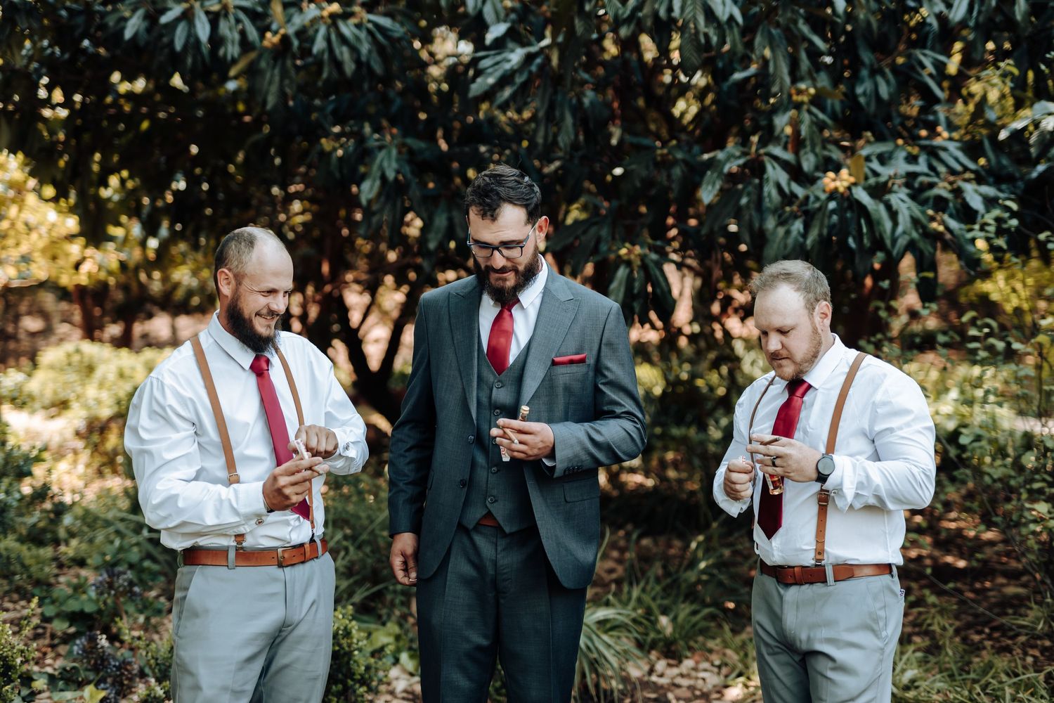 Wedding party members enjoy beverages during informal outdoor photo session.