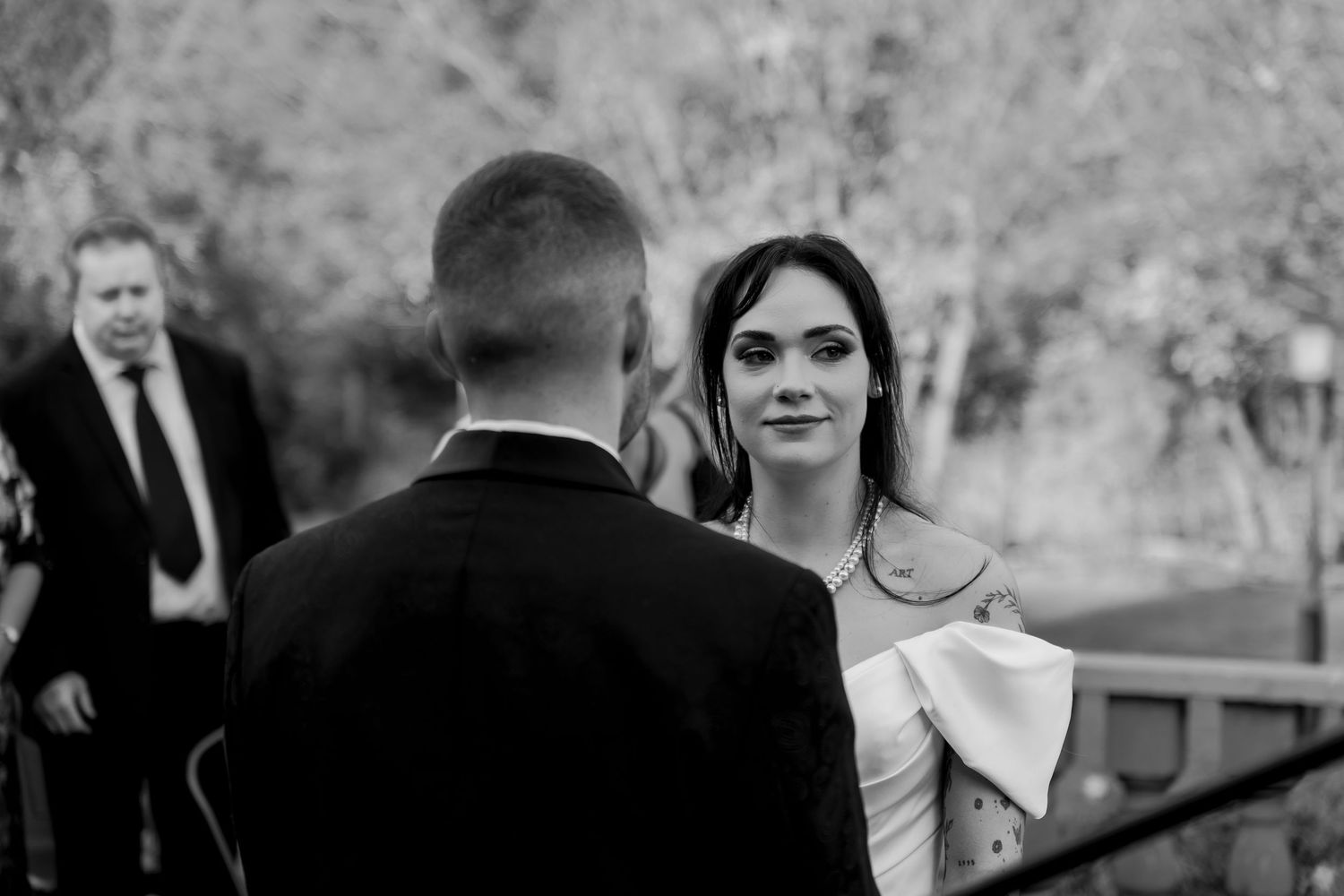 Black and white wedding photographs arranged in a collage format showing candid moments and celebrations at an outdoor event.