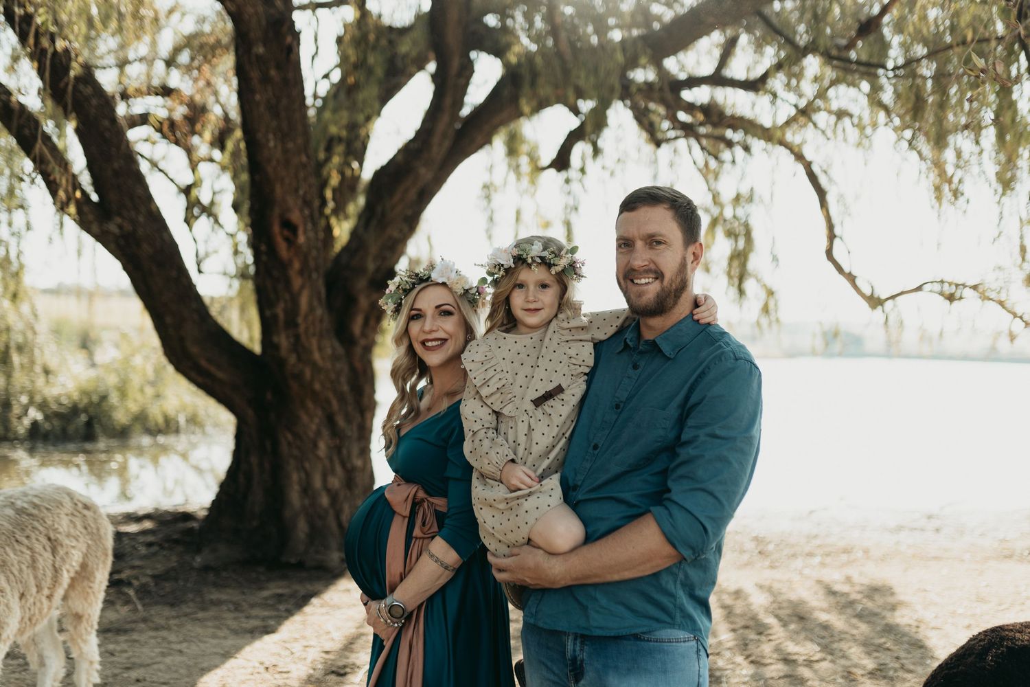 Happy family with a young child enjoying a sunny afternoon under Spanish moss covered trees.