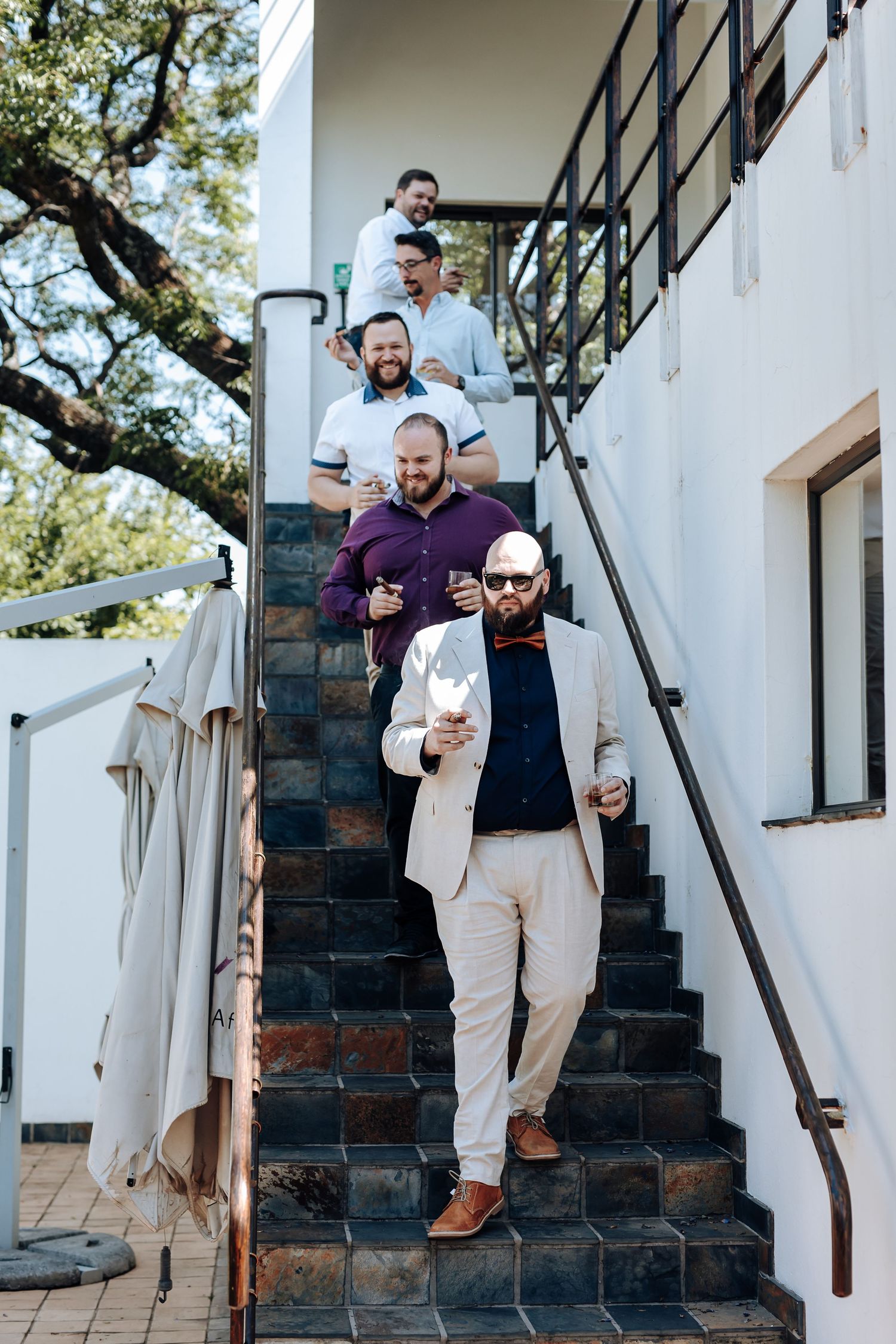 People walking down outdoor stone steps against a white wall in a sequence of candid moments.