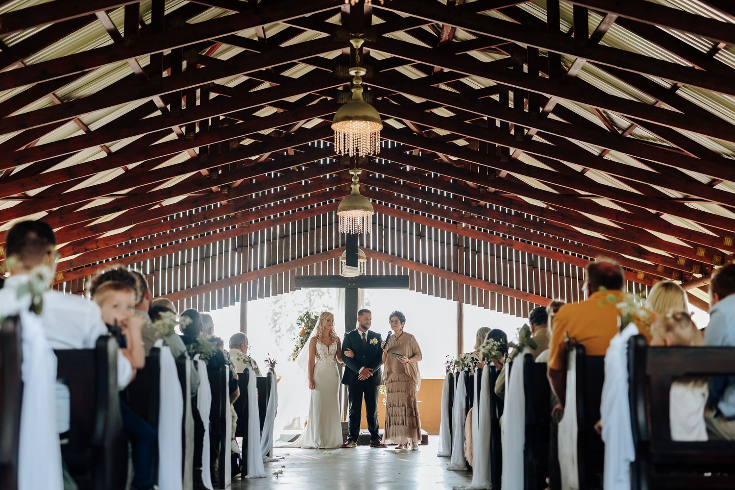A long wooden pavilion with exposed beams and pendant lights showcases traditional architectural details and warm lighting.